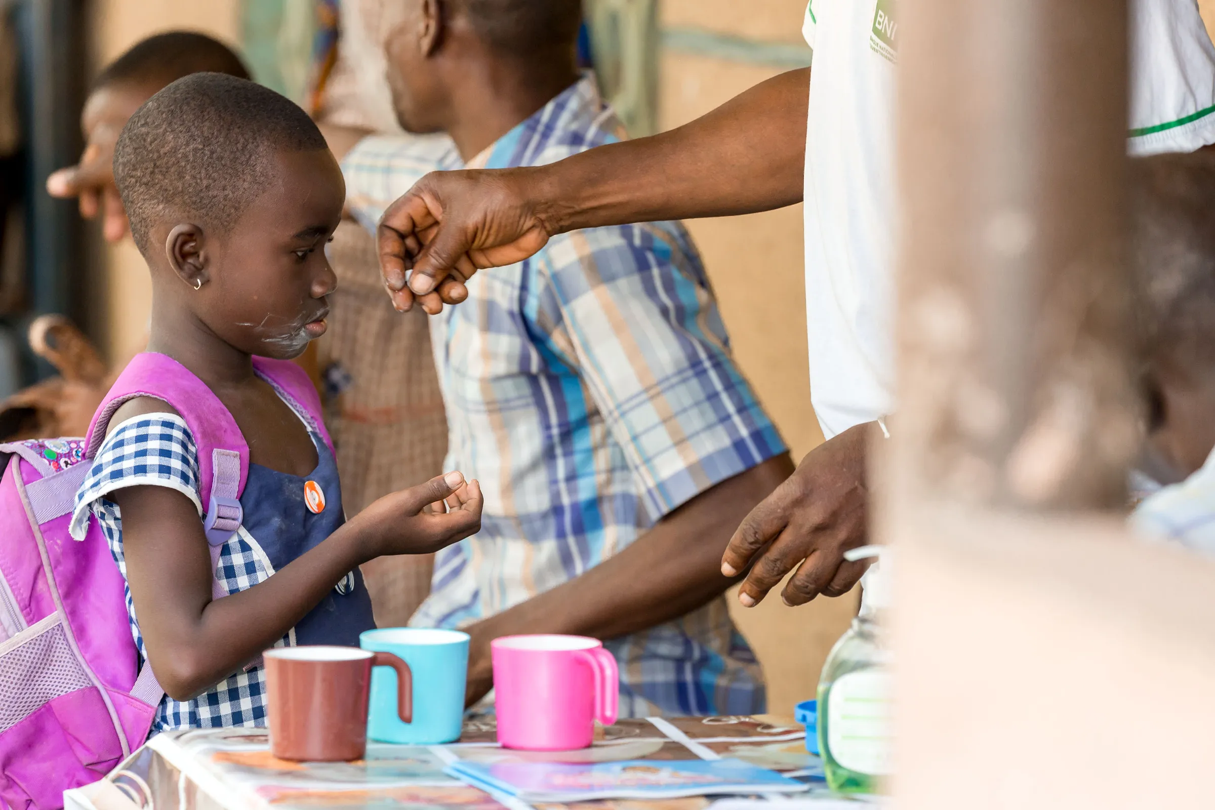 A child receives a dose of a drug to treat schistosomiasis during a treatment campaign in 2016. Merck/Handout via Thomson Reuters Foundation