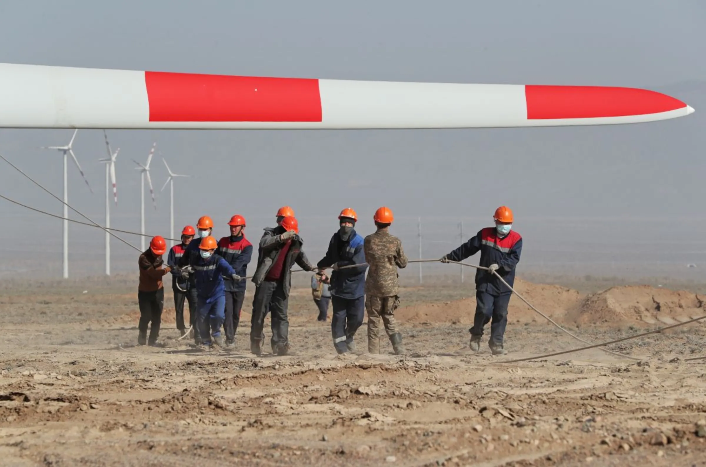 Workers install a rotor blade on a power-generating wind turbine during a construction of a wind farm by Kazakh company Samruk-Energy in cooperation with the Chinese PowerChina Corporation in the Almaty region, Kazakhstan April 7, 2022. REUTERS/Pavel Mikheyev