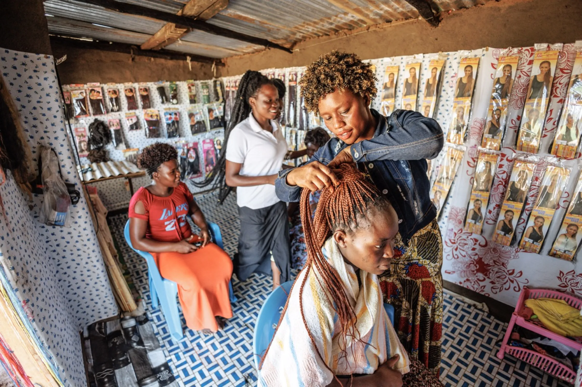 Viola works at her hair salon in Bidi Bidi camp in Uganda in 2024. Photo by Jjumba Martin for Village Enterprise/Handout via Thomson Reuters Foundation