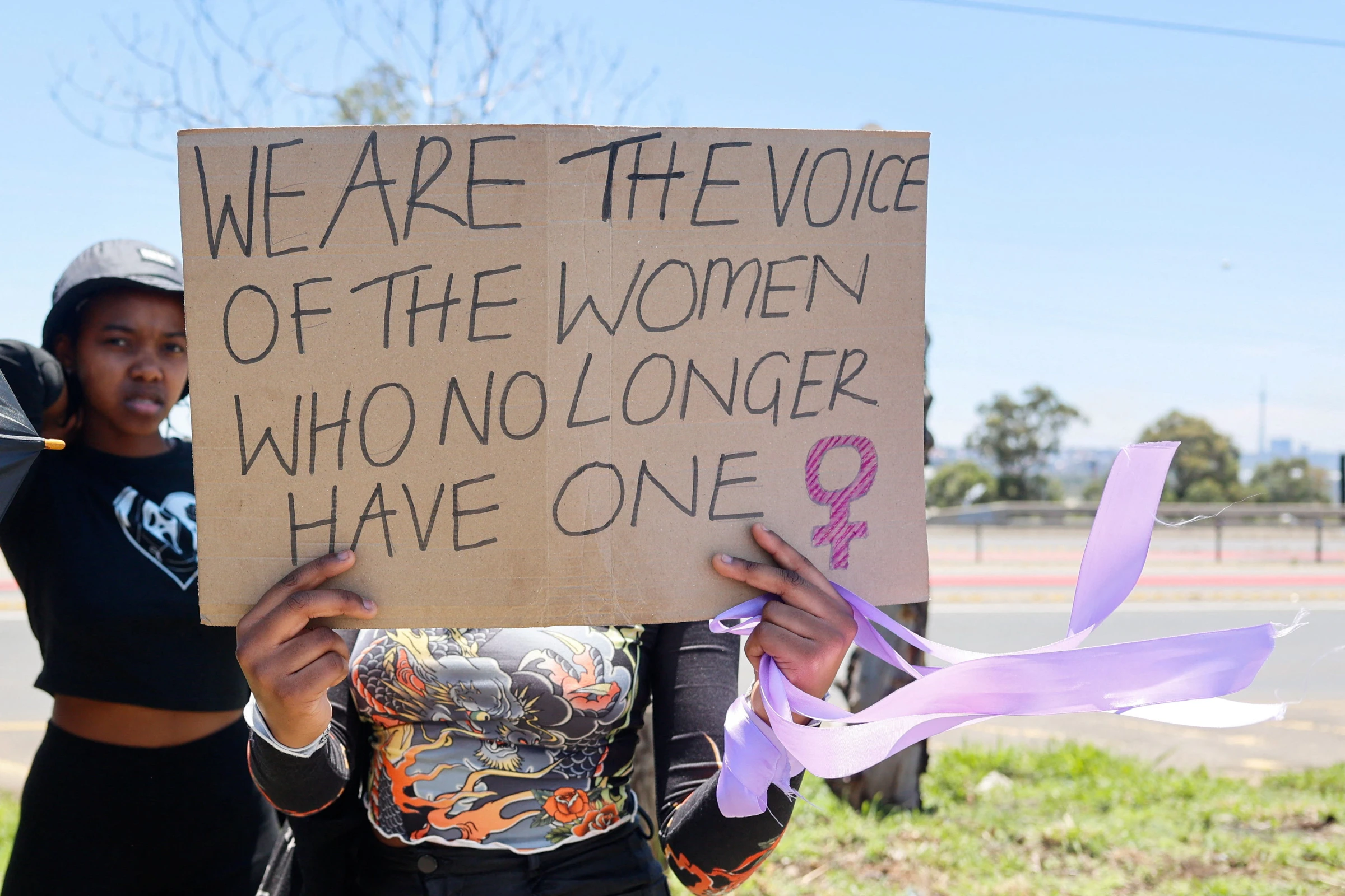 A person holds a placard, during a protest against gender-based violence, outside of the Nasrec Expo Centre during the opening day of the G20 leaders' Summit, in Johannesburg, South Africa, November 22, 2025. REUTERS/Alet Pretorius