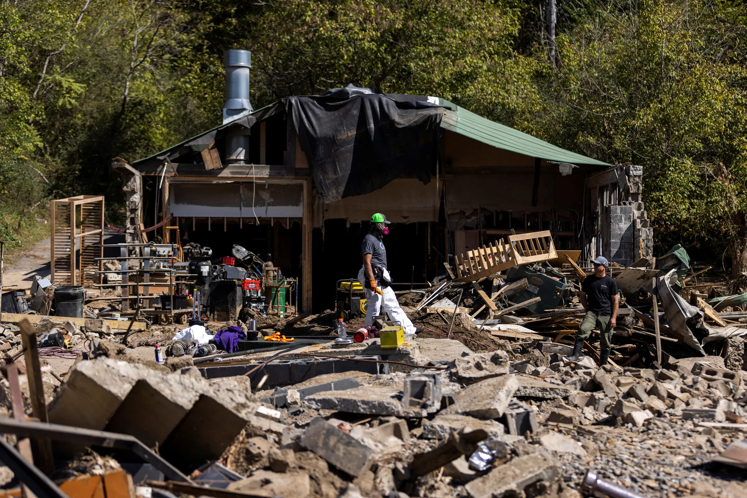 A resident walks through debris following the passing of Hurricane Helene, in Marshall, North Carolina, U.S., October 8, 2024. REUTERS/Eduardo Munoz