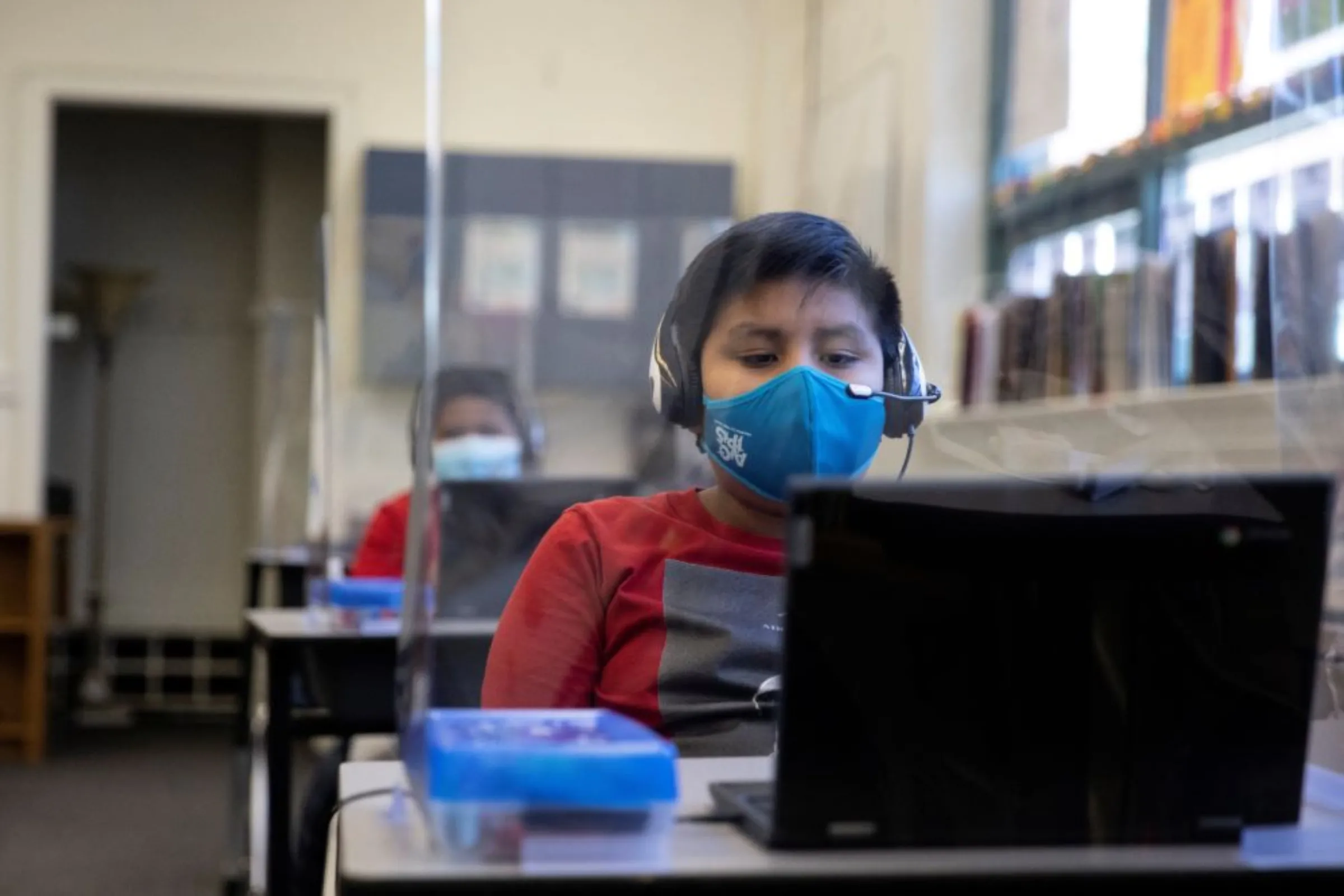 A student uses a computer from a socially-distanced desk during an in-person hybrid learning day at the Mount Vernon Community School in Alexandria, Virginia, U.S., March 2, 2021. REUTERS/Tom Brenner