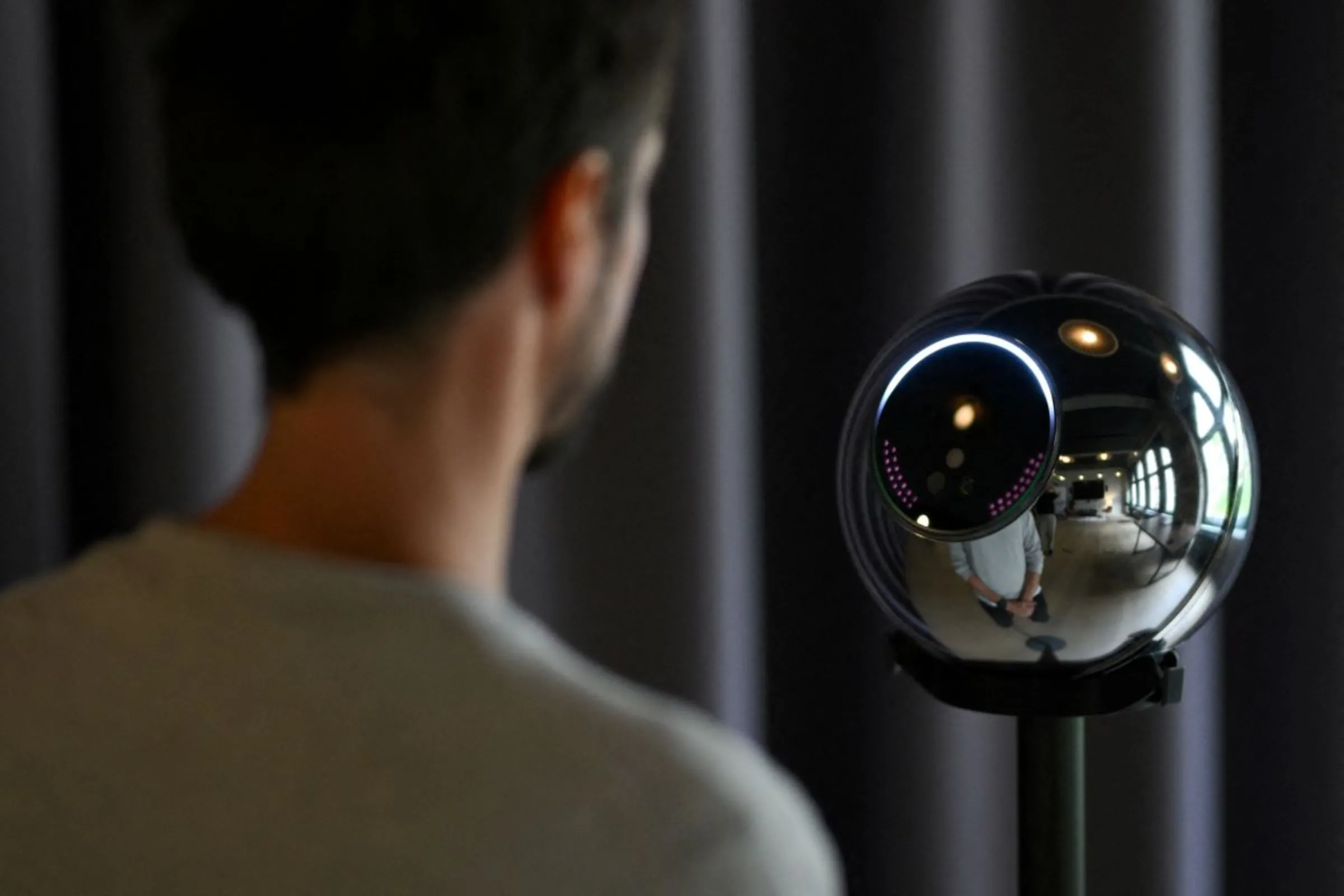 Ricardo Macieira, regional manager, Europe stands to simulate the iris scan near the biometric imaging device, the Orb of the identity and financial public utility Worldcoin, to create a World ID digital passport, being able to trade in cryptocurrency issued, in Berlin, Germany