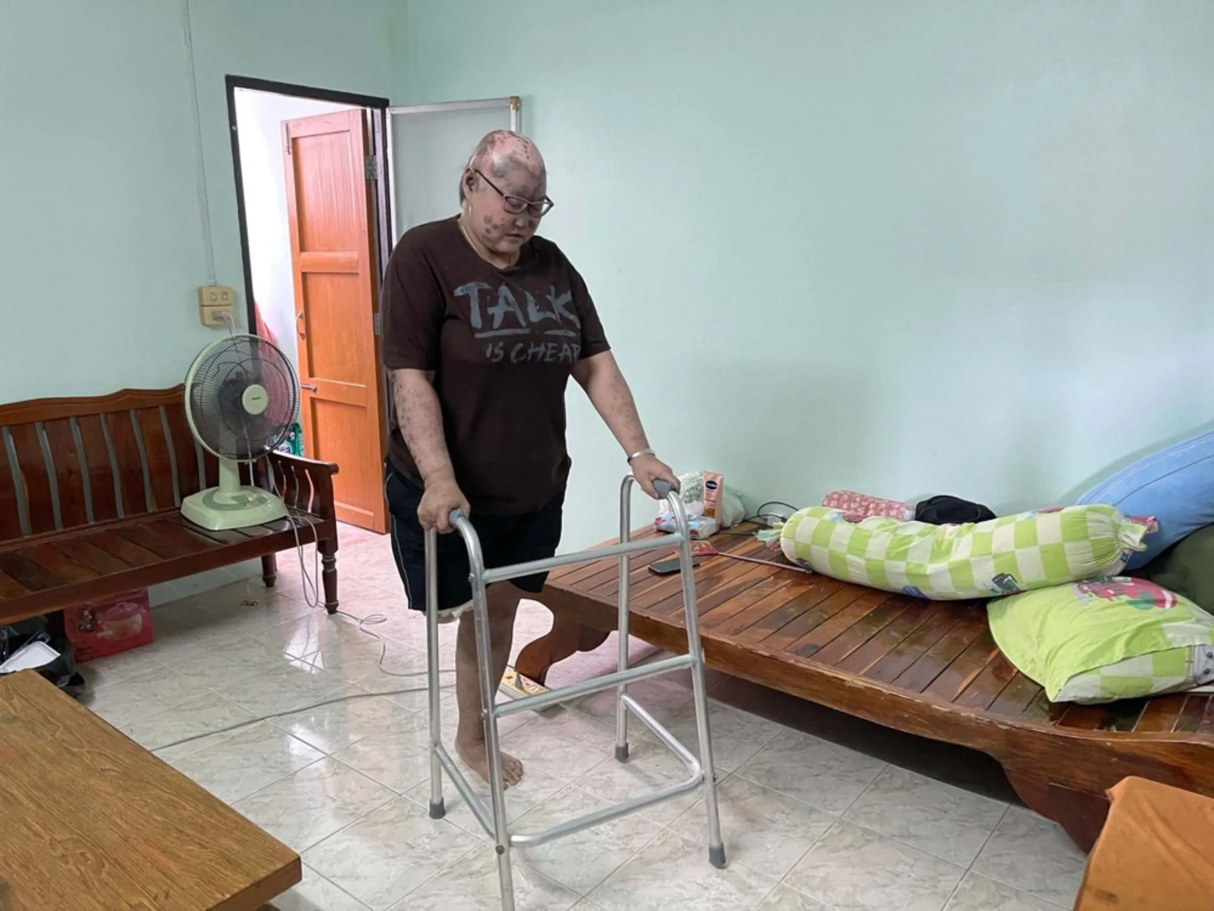 Maneewan Maneesecom uses a walker in his home in Ayutthaya, Thailand on October 3, 2021