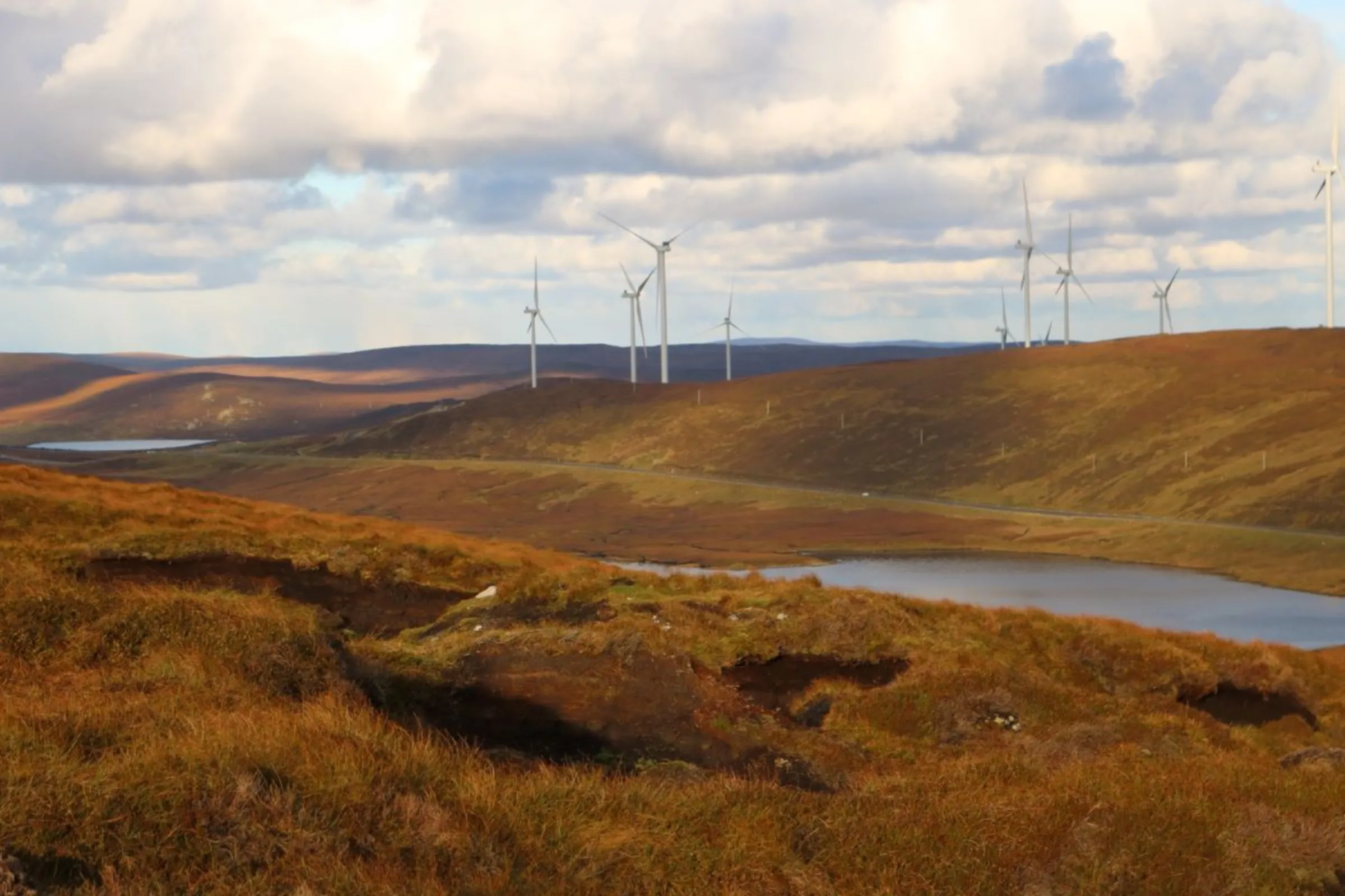 Degraded peatlands scar the landscape in Shetland, as if the land were gashed by a giant knife, overlooked by turbines from the Viking Energy windfarm coming online in 2024, on Mainland, Shetland, Scotland, November 1, 2023. Thomson Reuters Foundation/Jack Graham