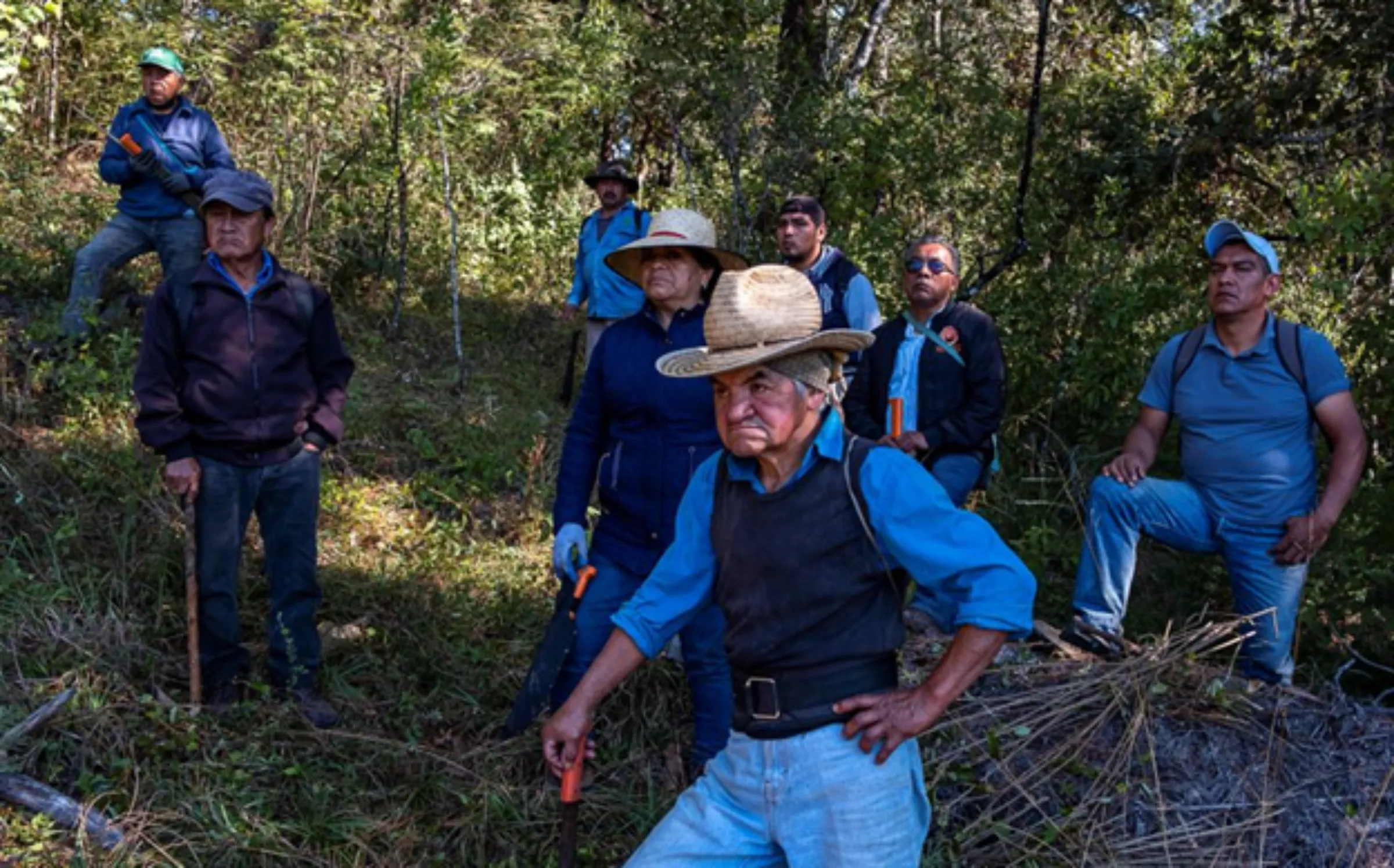Men rest after a collective work of clearing the forest near Capulálpam de Mendéz, Mexico, December 11, 2022. Thomson Reuters Foundation/Noel Rojo