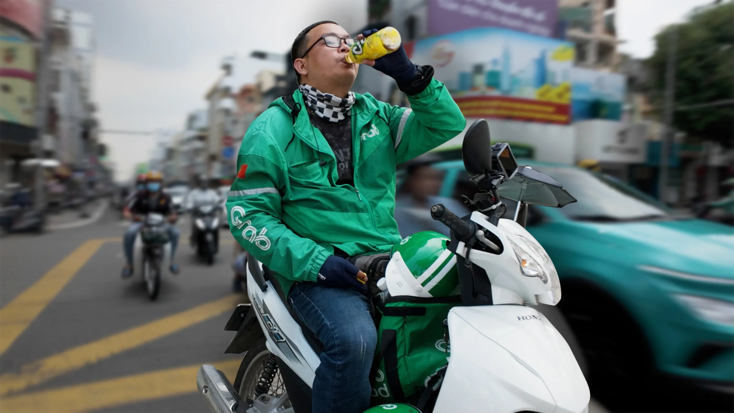 A still of delivery driver Pham Van Nam drinking while on his moped from the Context video Extreme weather is forcing Vietnam's gig workers to choose between safety and survival. Thomson Reuters Foundation/Lam Le/Duy Linh Tu/Sebastian Tuinder