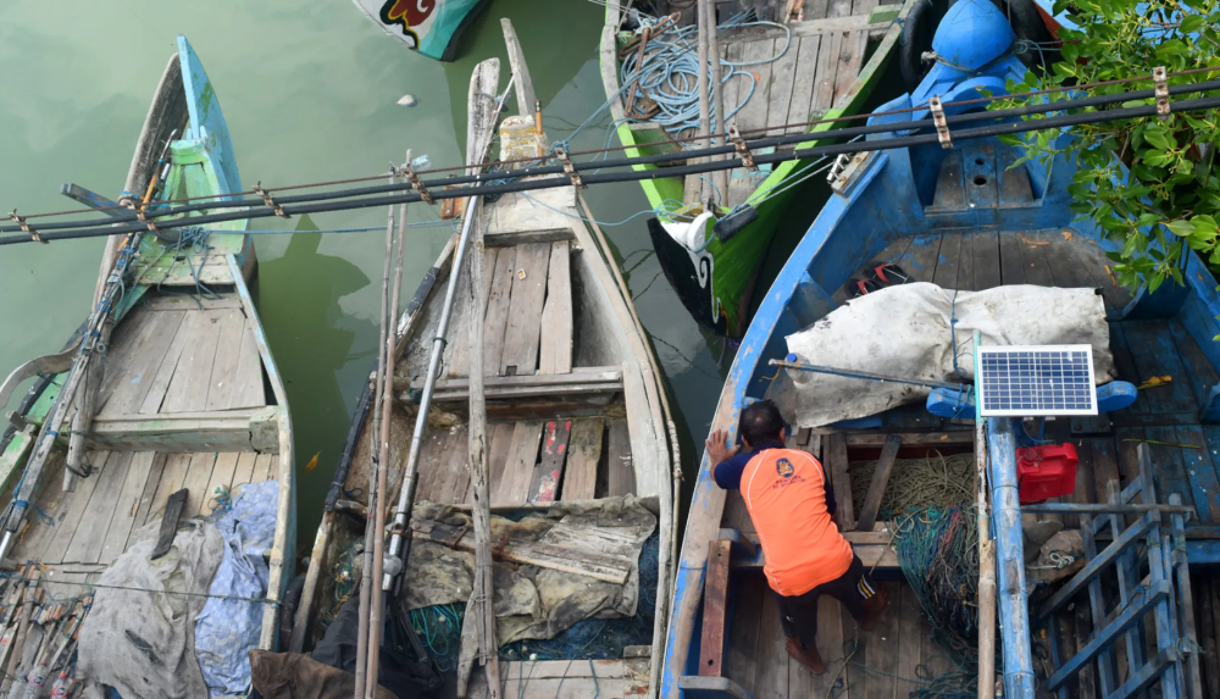 A fisherman checks the condition of a boat on the Karanggeneng River, in Central Java, Indonesia, August 12, 2022