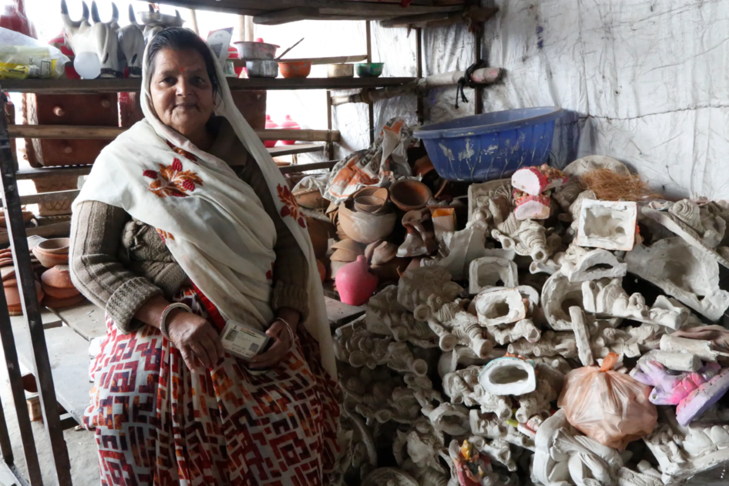 A woman borrower poses for a photo at her pottery shop, which she started with the help of a microloan, in Bhopal, Madhya Pradesh, November 10, 2022