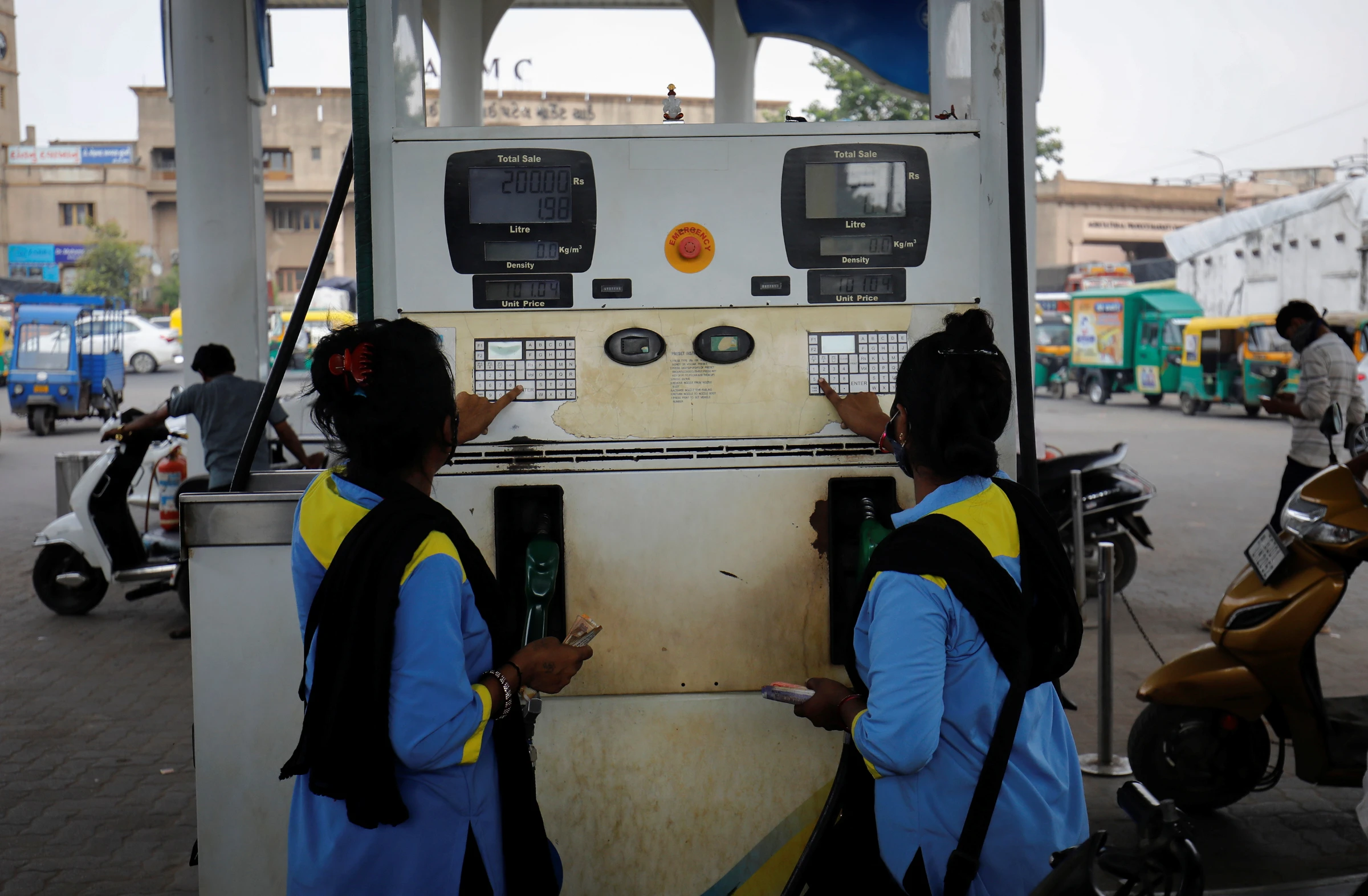 Workers enter the amount into a fuel pump machine before filling up the vehicles at a petrol station in Ahmedabad, India, October 11, 2021. REUTERS/Amit Dave