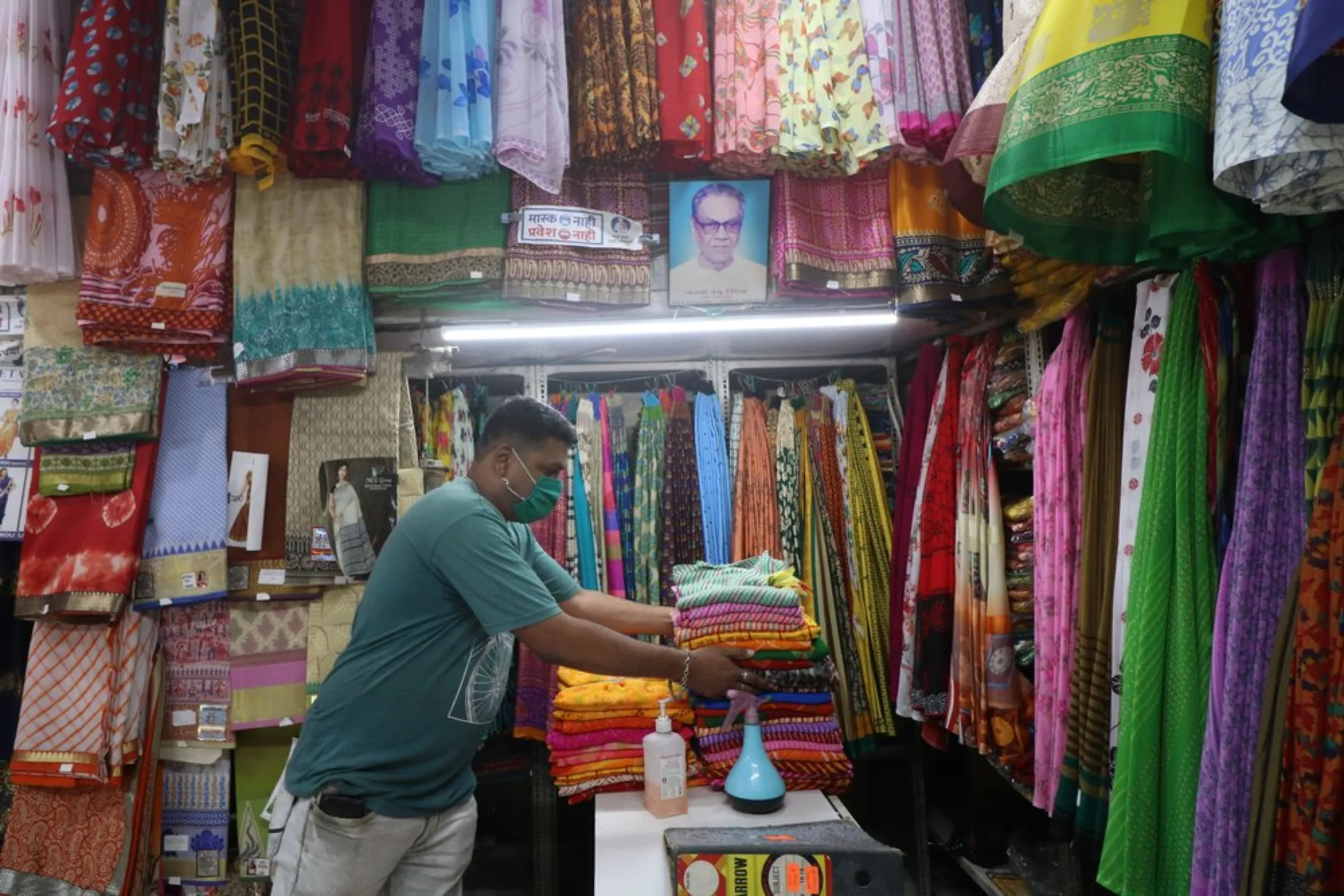 Harish Dadhia, the owner of a flood-prone sari shop, arranges his wares at the Hindmata market in Mumbai, India, September 7, 2021