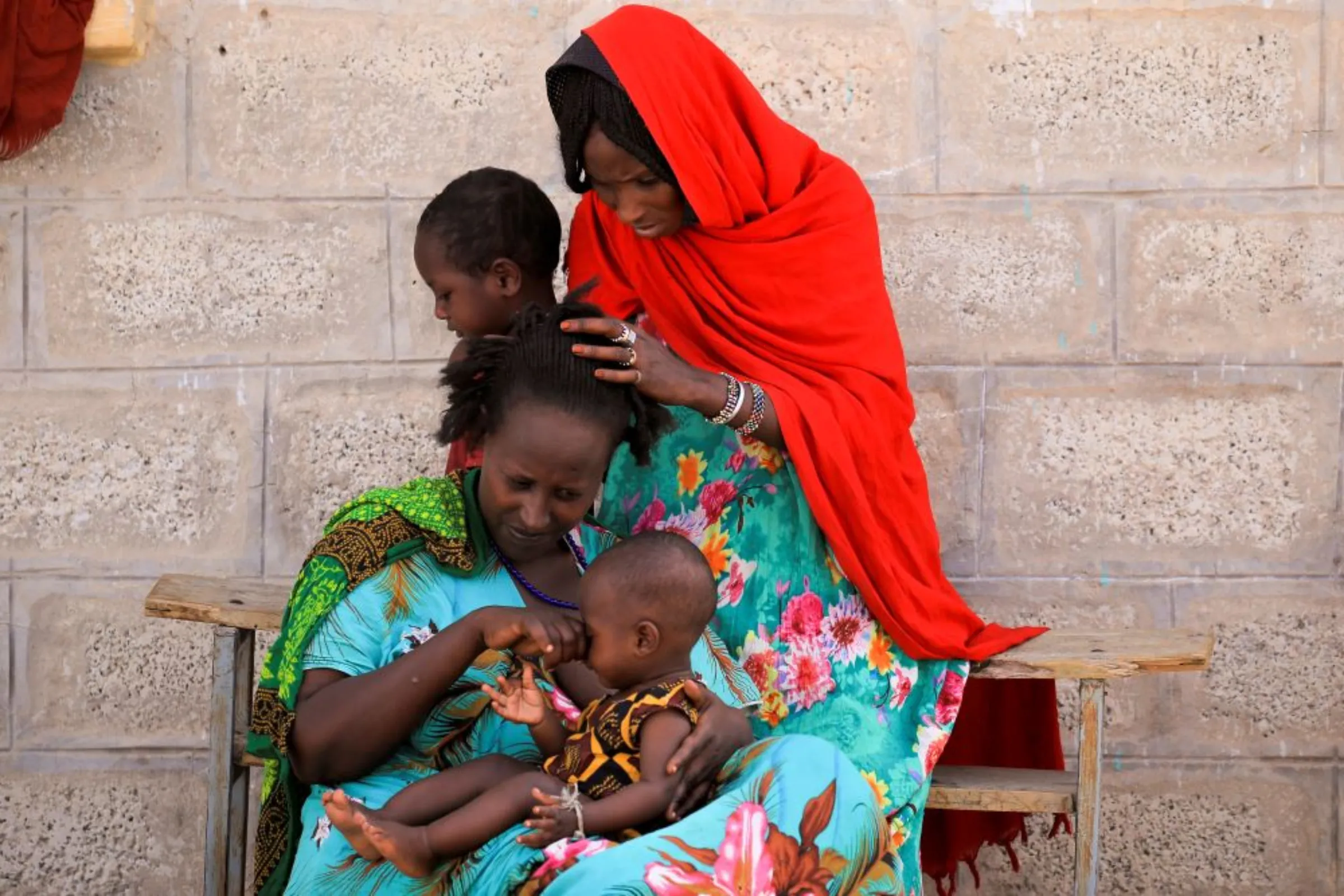 An internally displaced family who fled their home in Berhale due to fighting between the Afar Special Forces and the Tigray People's Liberation Front (TPLF) forces sit in front of their shelter at a makeshift compound in Afdera town, Ethiopia, February 23, 2022