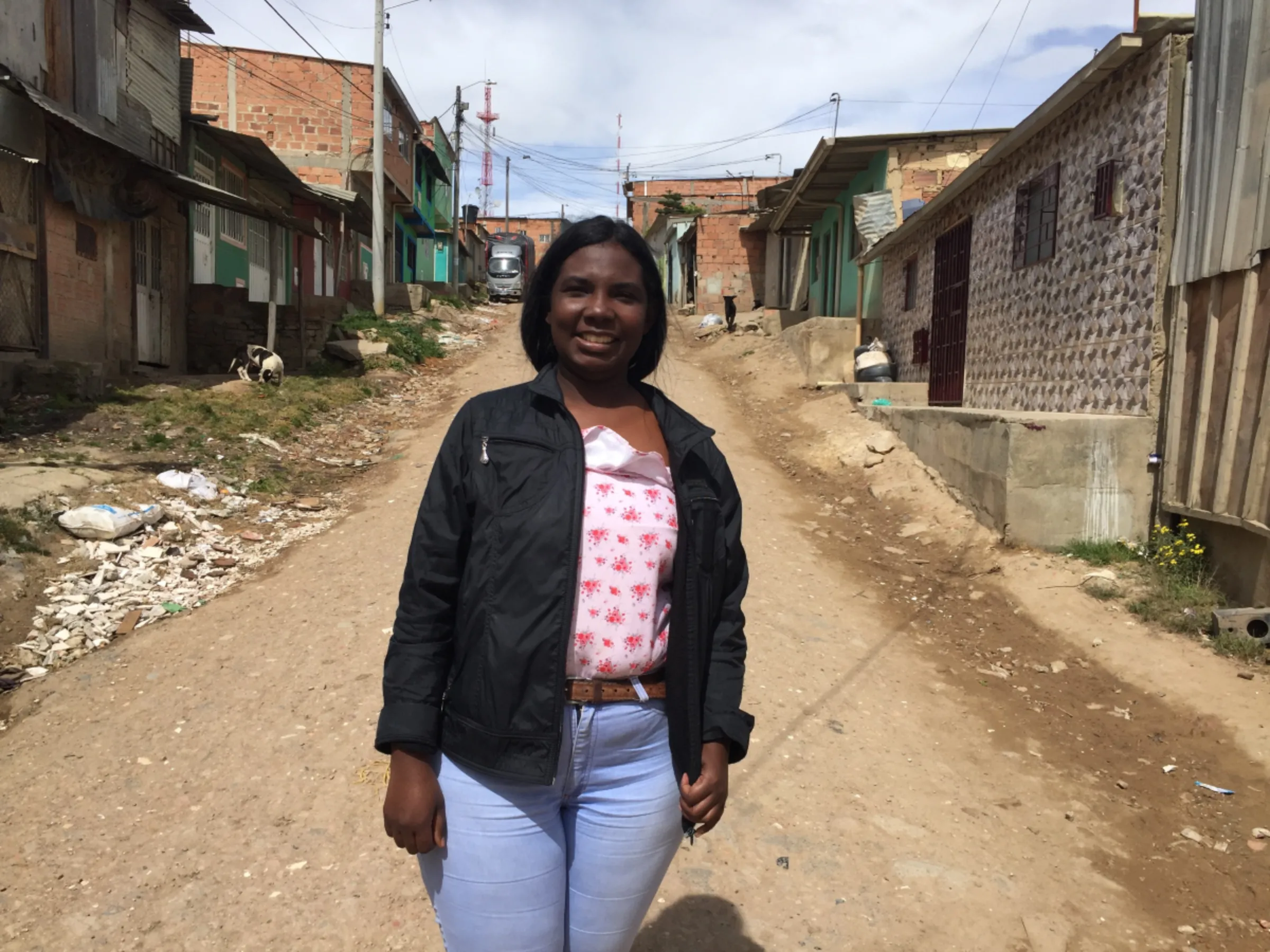 Venezuelan migrant Franmaryoli Hernandez in a street outside her rented home, Soacha, Colombia. July 23, 2021. Thomson Reuters Foundation/Anastasia Moloney