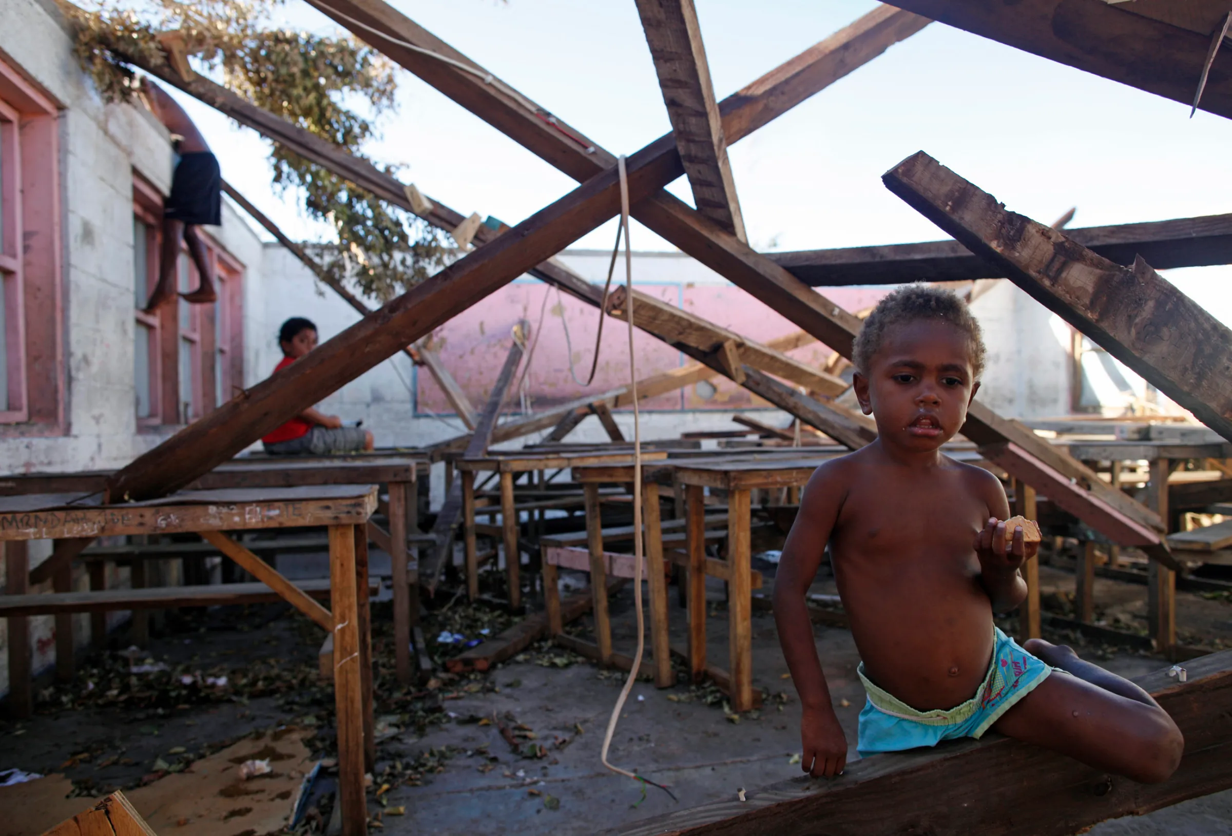 Children play in a destroyed school classroom in Tanna, Vanuatu March 18, 2015. REUTERS/Edgar Su