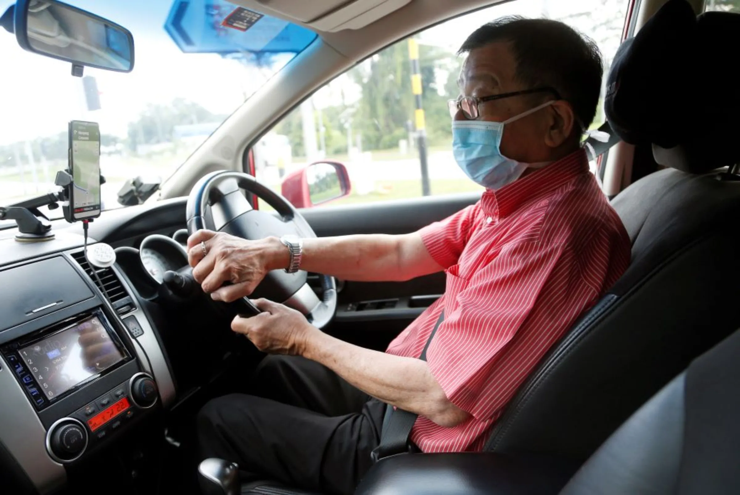 A private hire car driver wears a mask in Singapore, January 28, 2020. REUTERS/Feline Lim