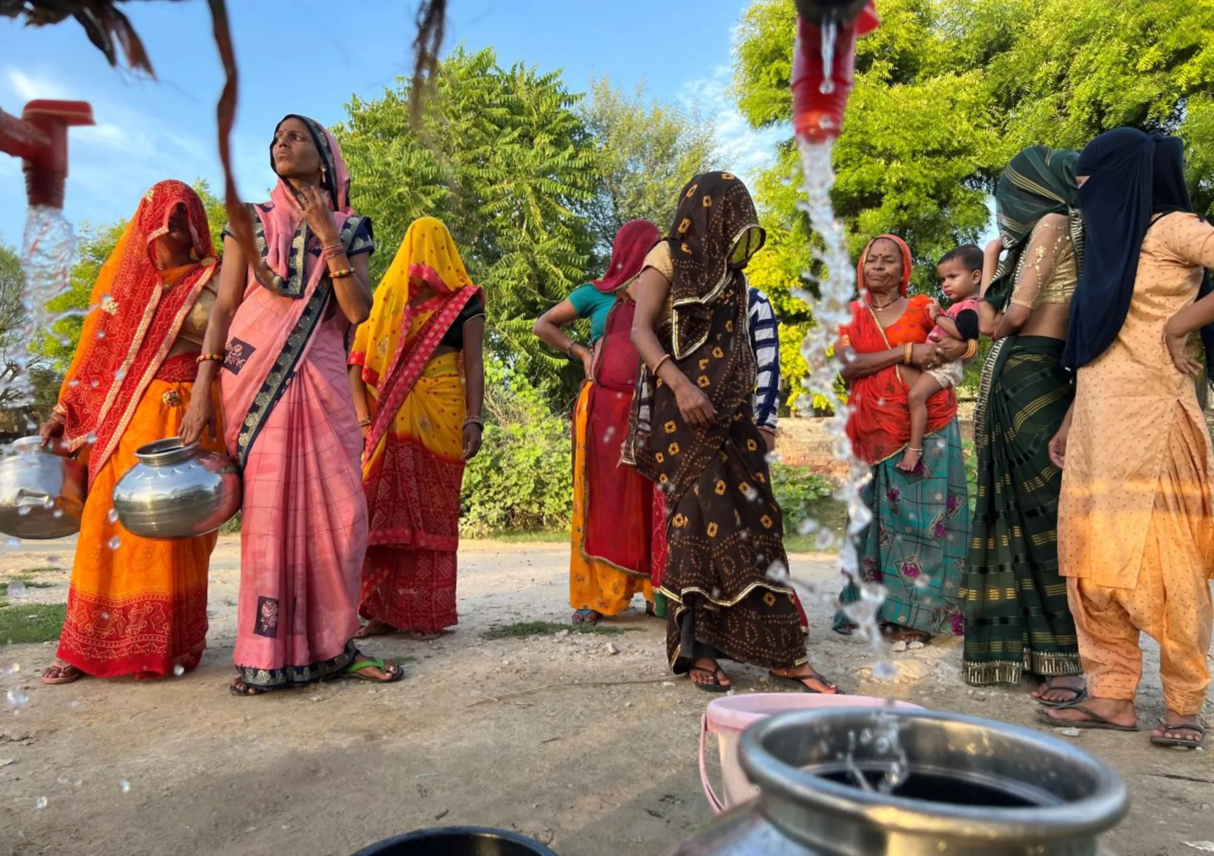 Women collect water from a public water tank in Karansar village in the Indian desert state of Rajasthan, India, August 26, 2022