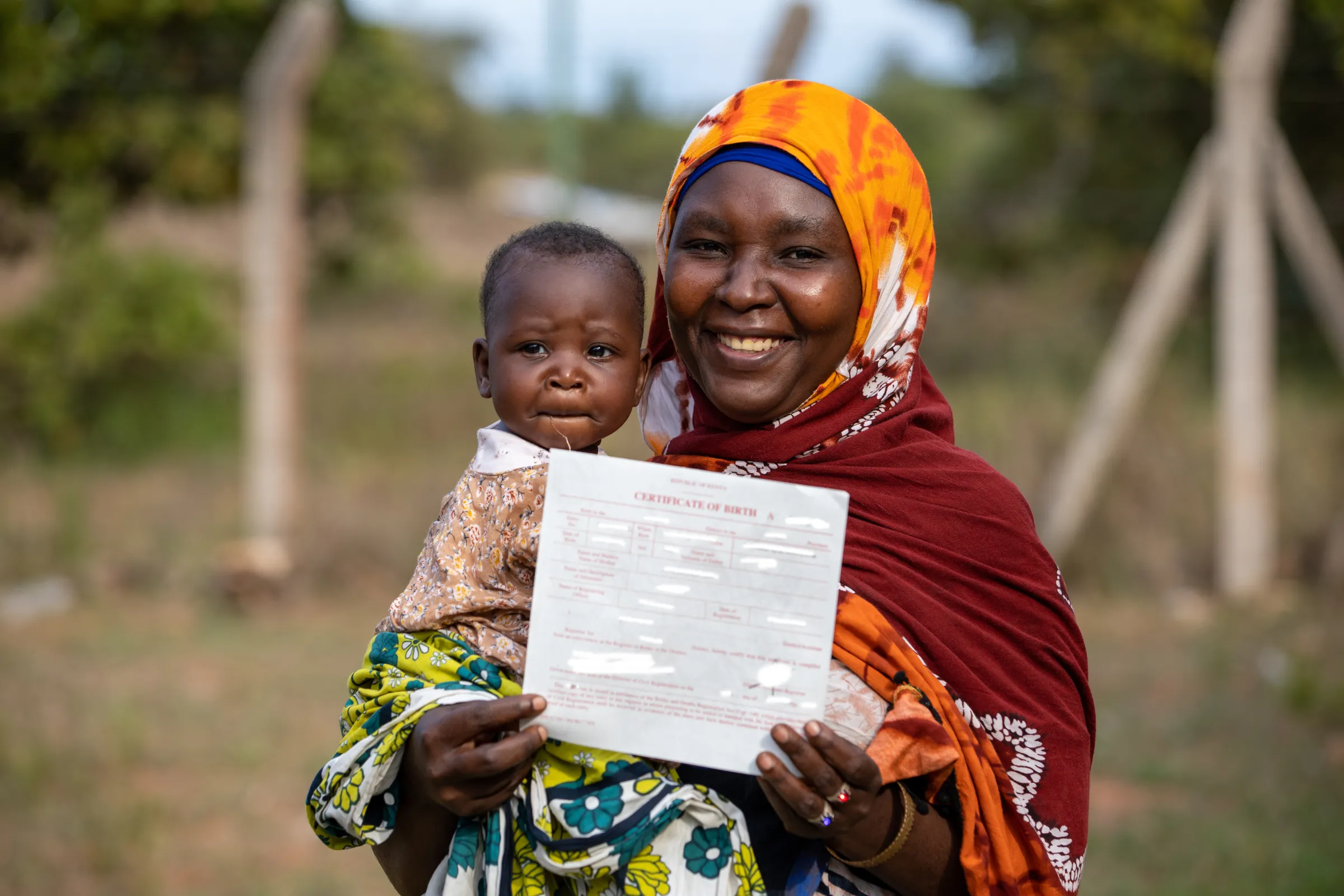 Asha Suleiman shows off her daughter's birth certificate. Kenya has granted citizenship to people from several ethnic groups who have long been stateless. Photo taken November, 2022. UNHCR/Charity Nzomo/Handout via Thomson Reuters Foundation