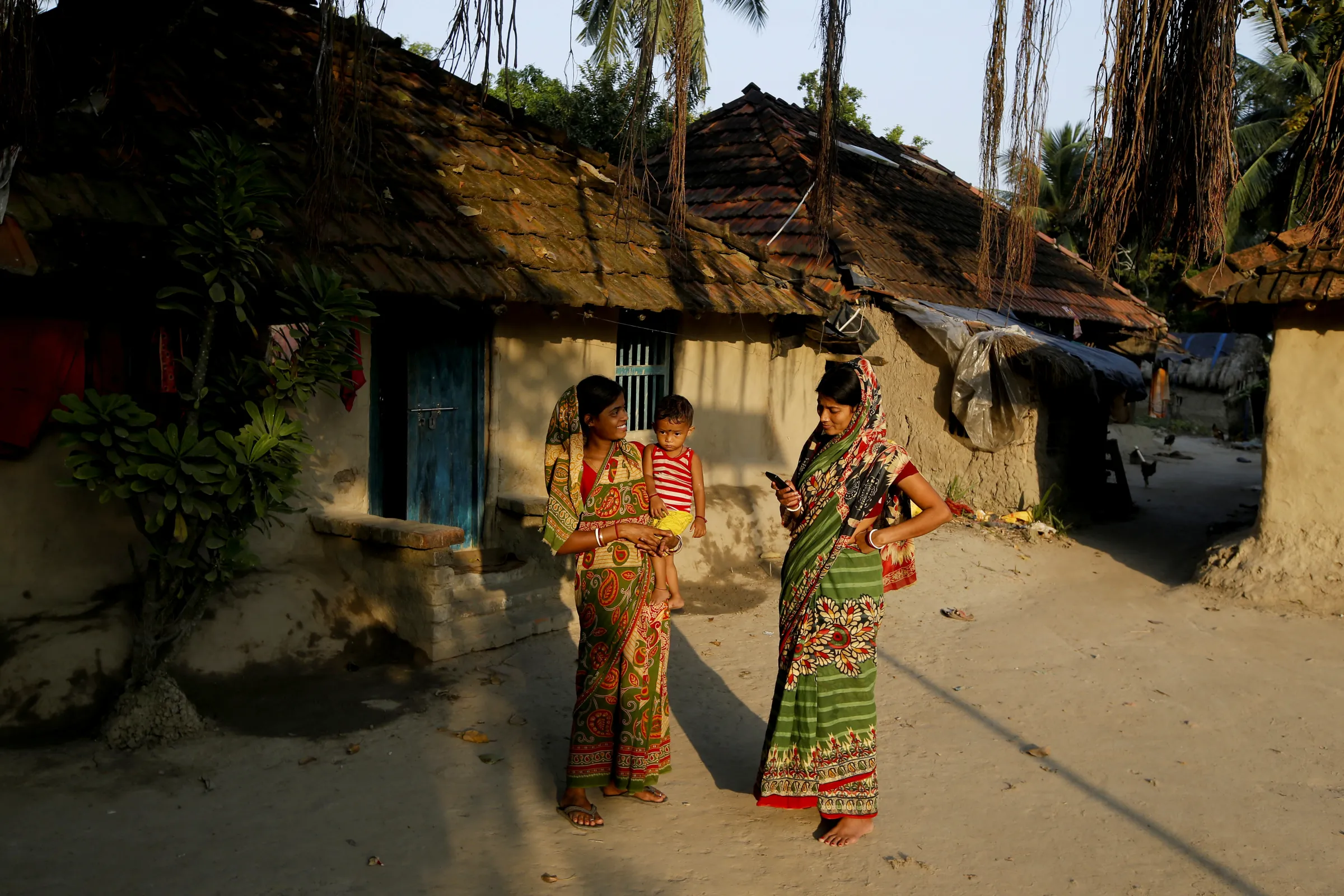 Women gesture after a phone call in front of their house on Ghoramara Island, India, November 16, 2018. REUTERS/Rupak De Chowdhuri