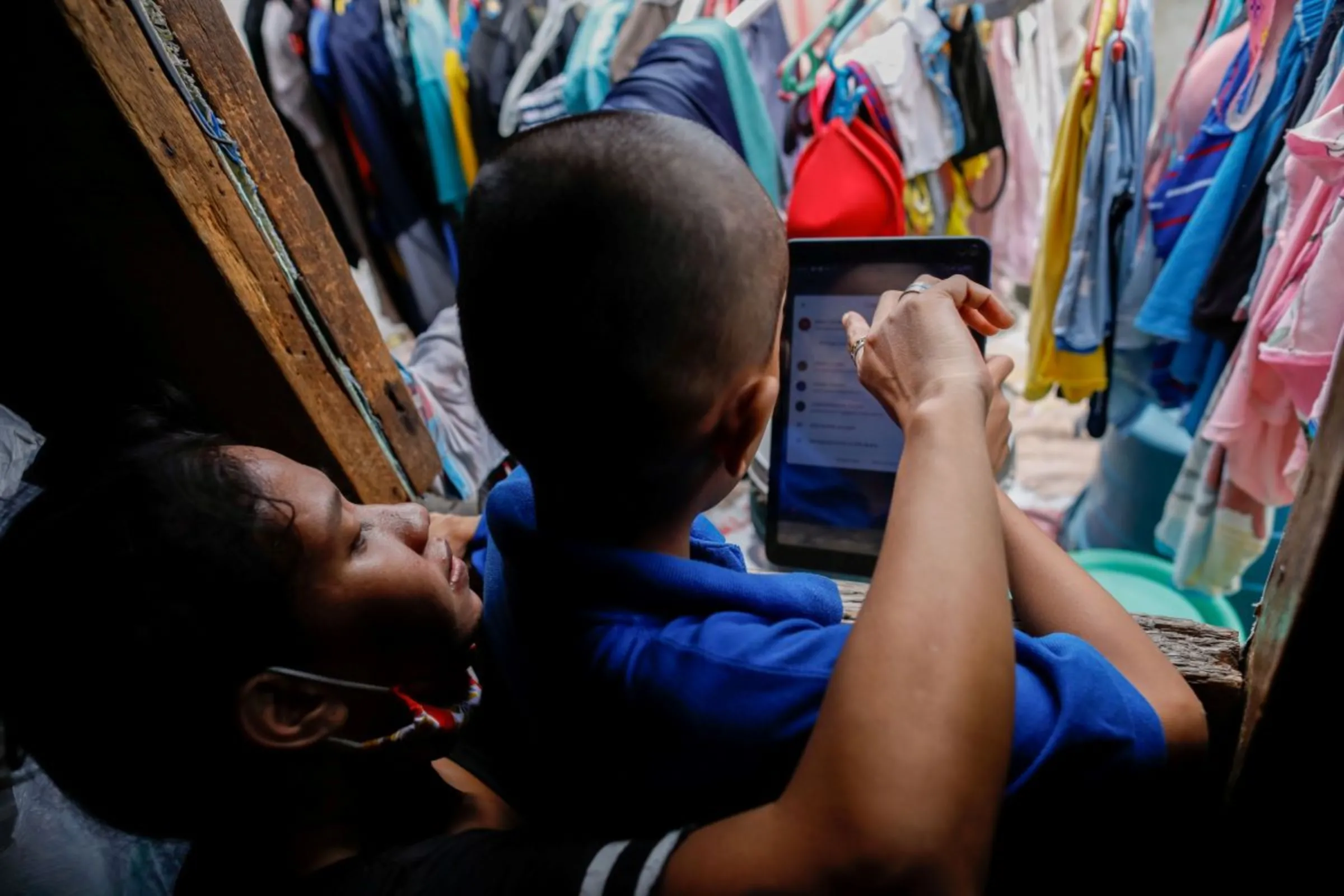 A student helped by his mother takes part in an online class in Manila, Philippines, October 30, 2020. REUTERS/Eloisa Lopez