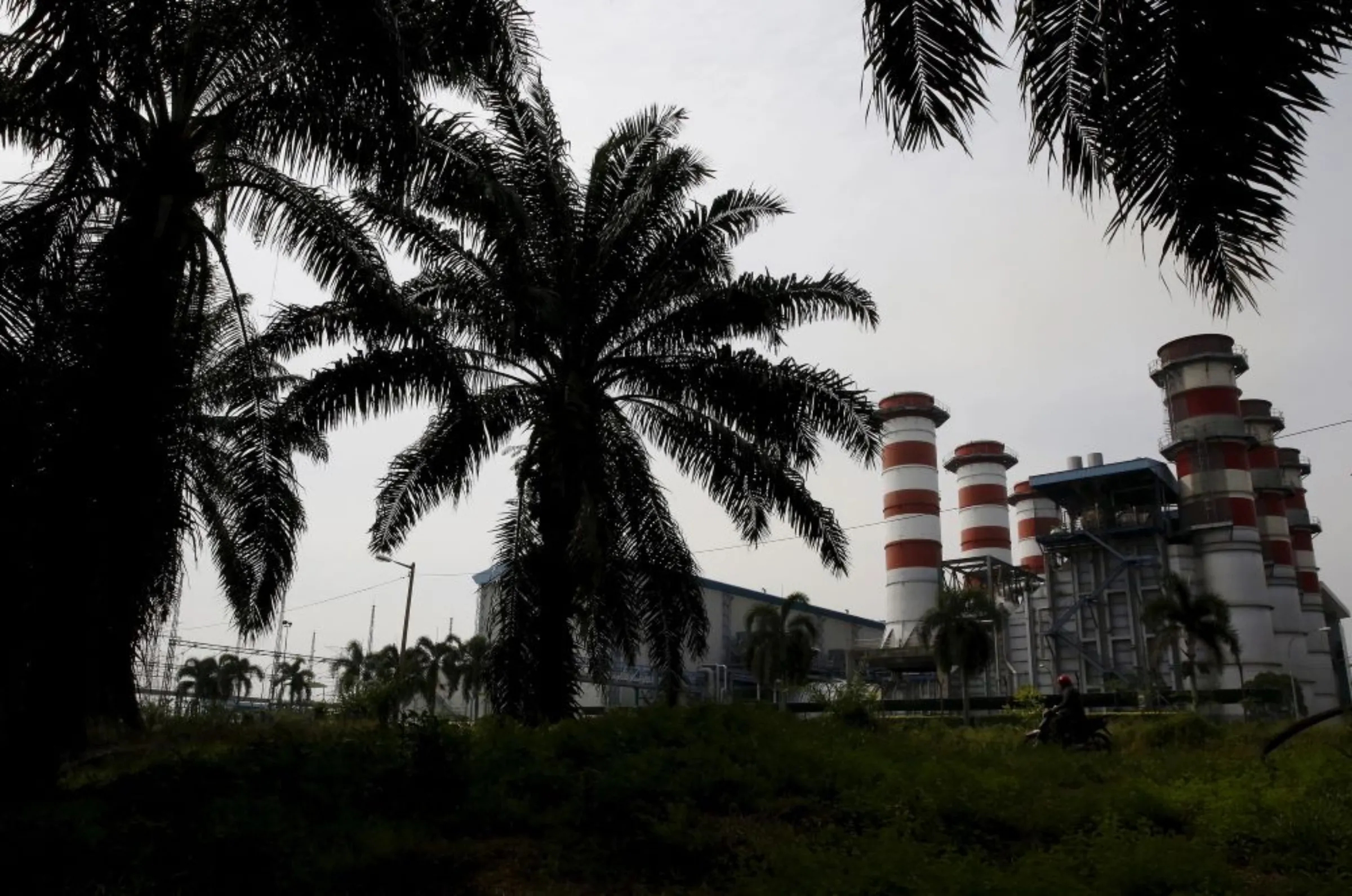 A motorcyclist passes the Kuala Langat Power Plant (KLPP), majority owned by troubled state investment fund 1MDB, in Banting outside Kuala Lumpur, Malaysia, July 7, 2015