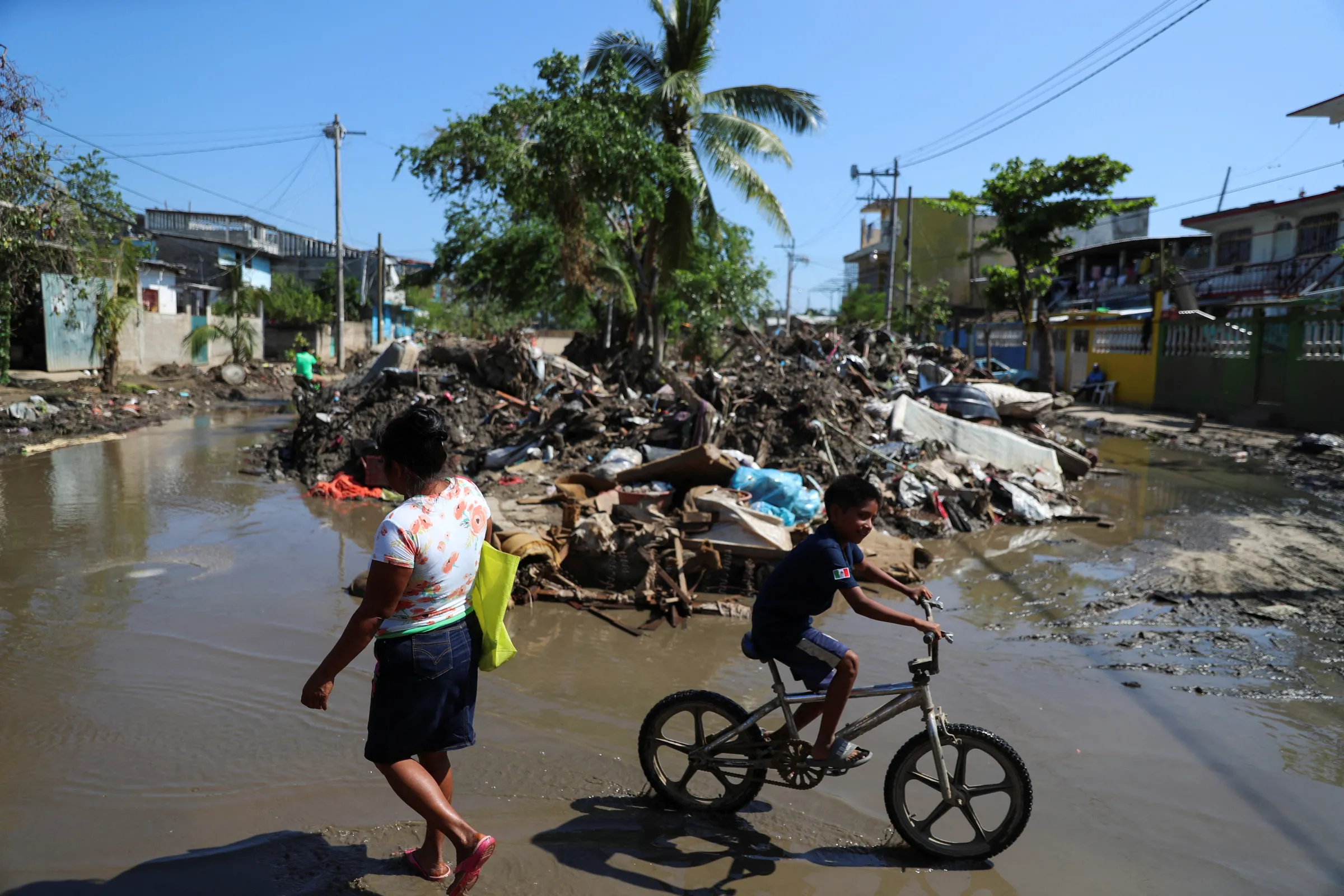 People pass by debris one month after Hurricane Otis hit, in Acapulco, Mexico November 24, 2023. REUTERS/Raquel Cunha