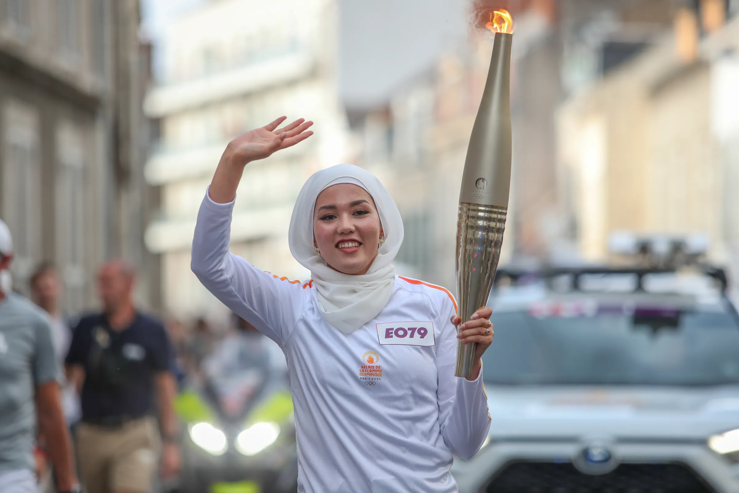 Masomah Ali Zada, chef de mission of the 2024 Olympic refugee team, carries the Olympic torch through Orleans, south of Paris, on July 10, 2024. International Olympic Committee (IOC)/
Handout via Thomson Reuters Foundation