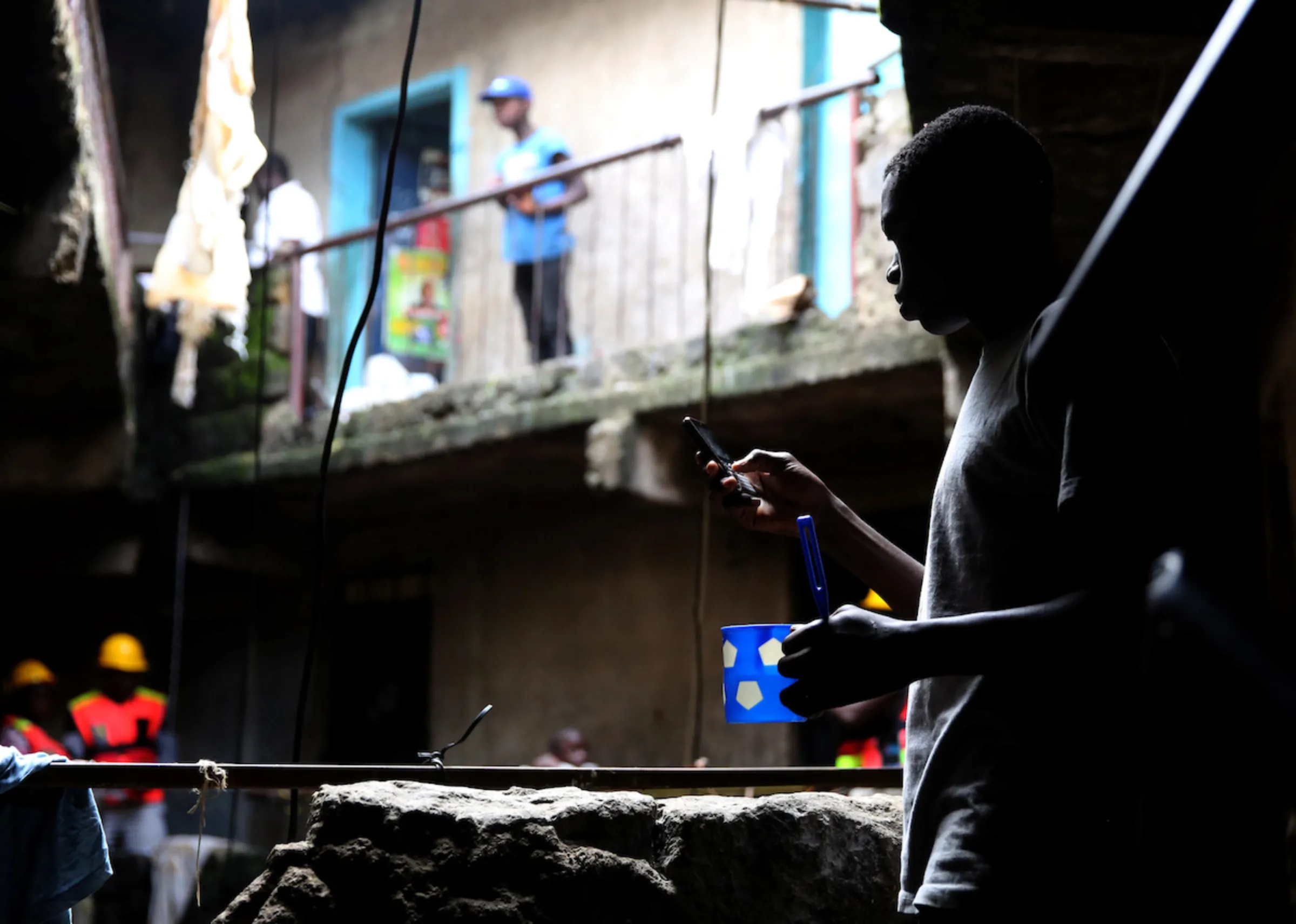 A man uses a cell phone in a building in the Mathare neighbourhood of Nairobi, Kenya, May 17, 2016