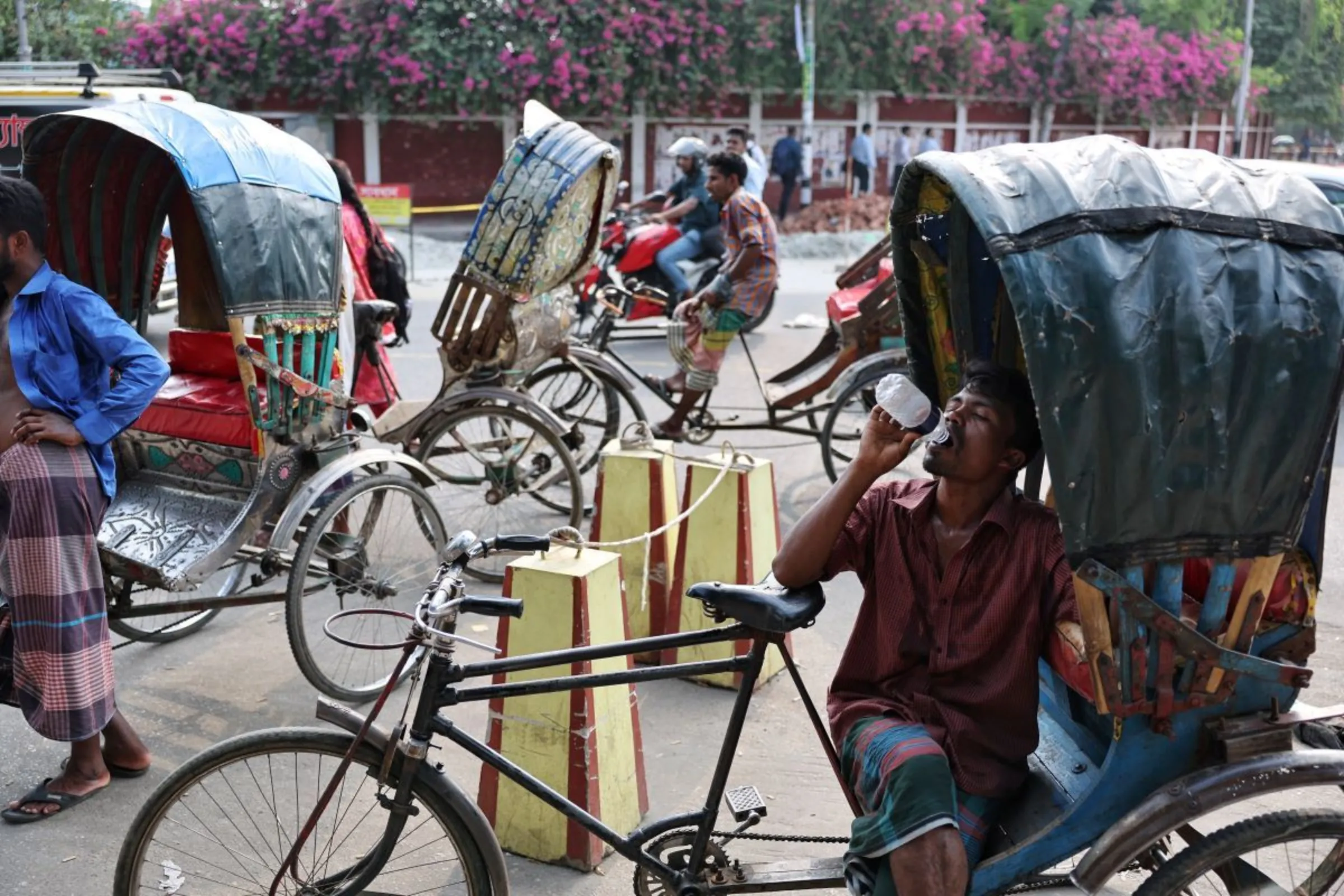 A rickshaw driver drinks water as he rests during ongoing heatwave in Dhaka, Bangladesh, April 30, 2024. REUTERS/Mohammad Ponir Hossain