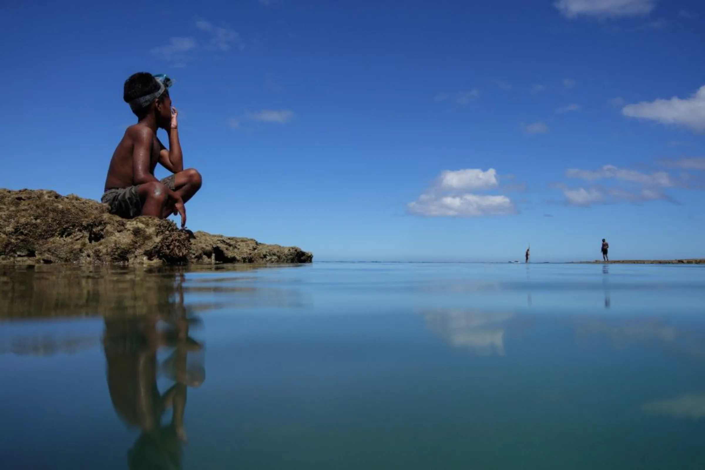 Local boy takes a break from diving in the sea at Serua Village, Fiji, July 14, 2022. As the community runs out of ways to adapt to the rising Pacific Ocean, the 80 villagers face the painful decision whether to move