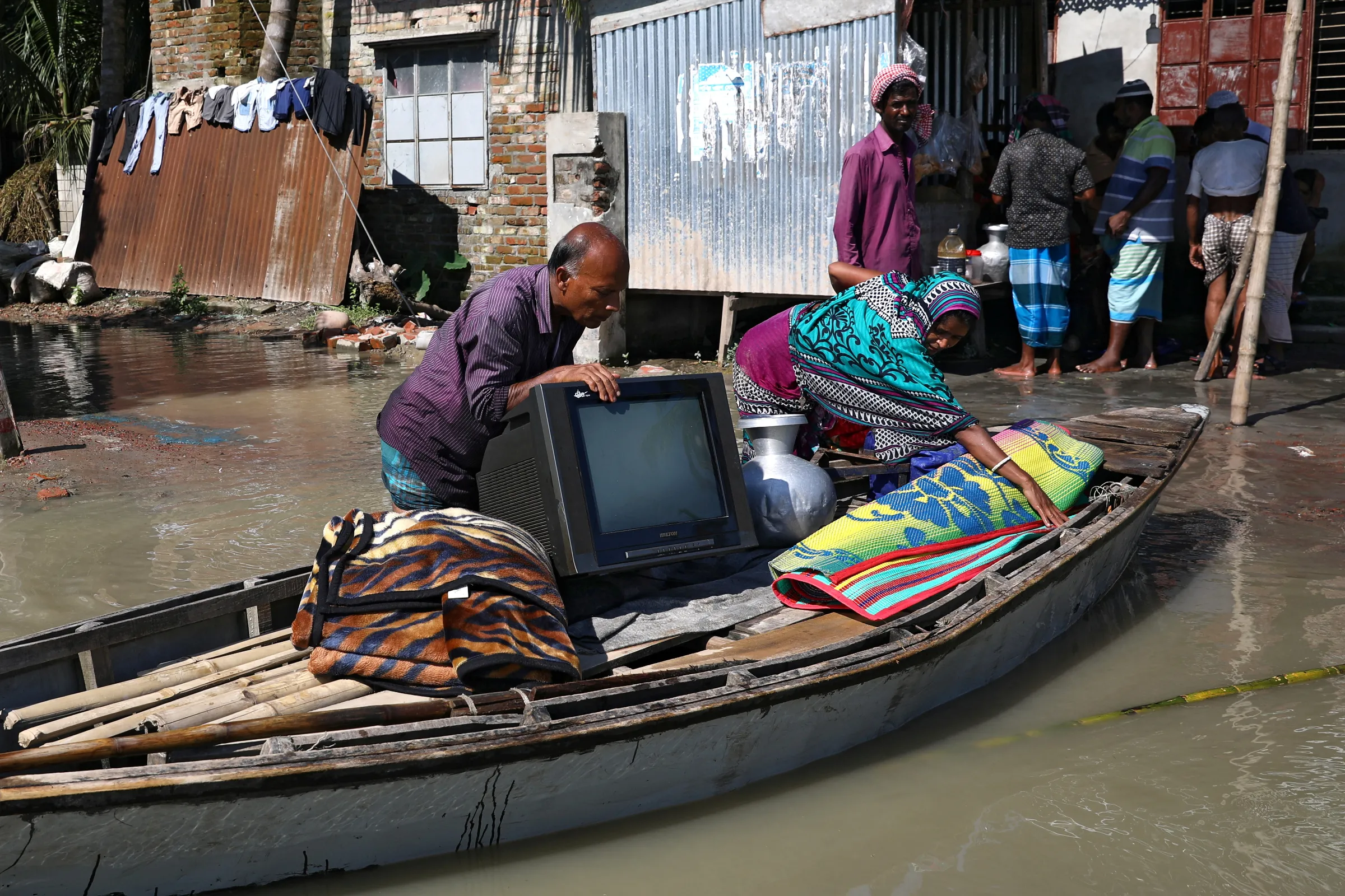 A family moves to a safe place with their belongings after the flood situation worsened in Munshiganj district, on the outskirts of Dhaka, Bangladesh, July 25, 2020. REUTERS/Mohammad Ponir Hossain