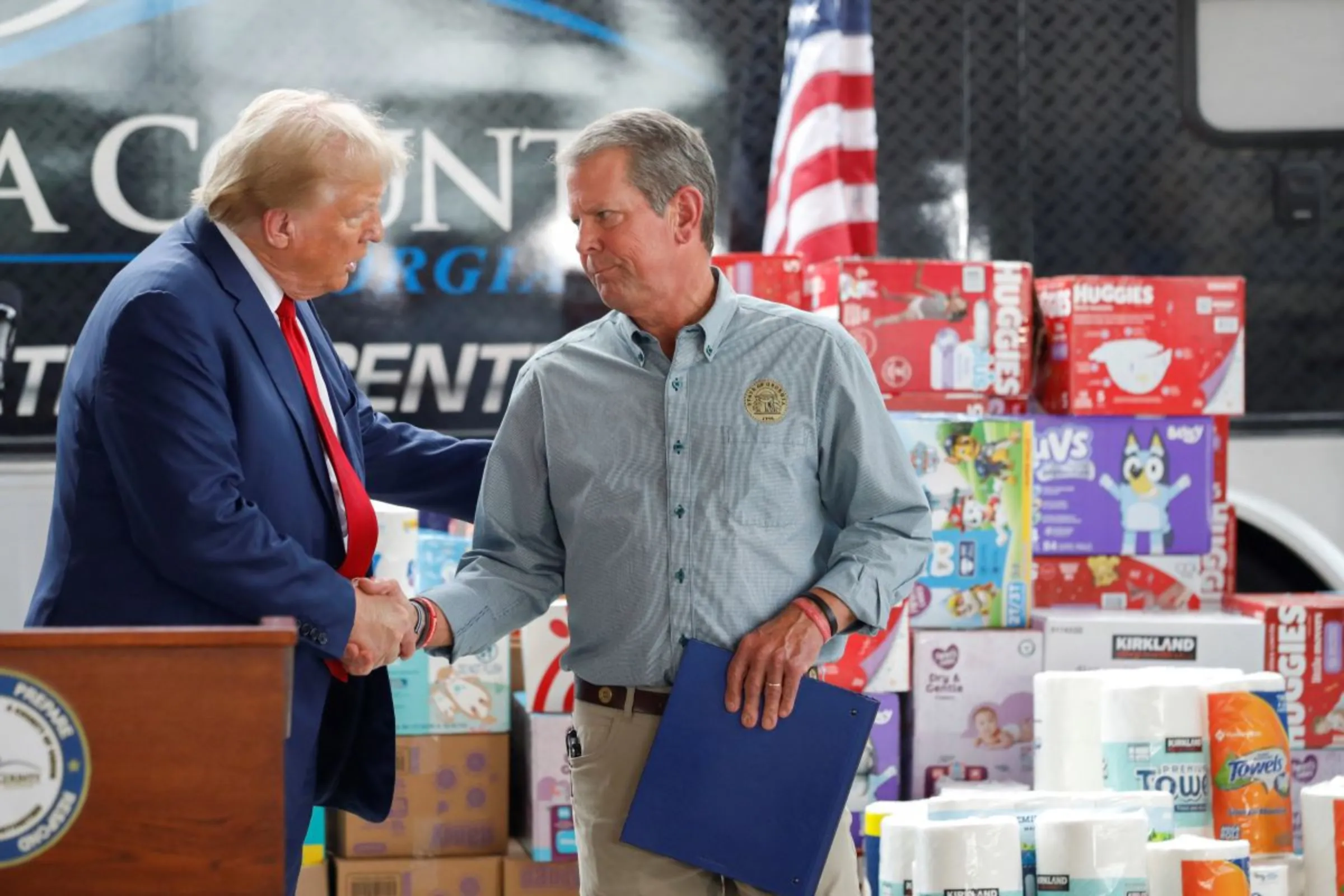 Republican presidential nominee and former U.S. President Donald Trump and Georgia Governor Brian Kemp shake hands on the day they speak to the press about the impact of Hurricane Helene in Evans, Georgia, U.S., October 4, 2024. REUTERS/Octavio Jones