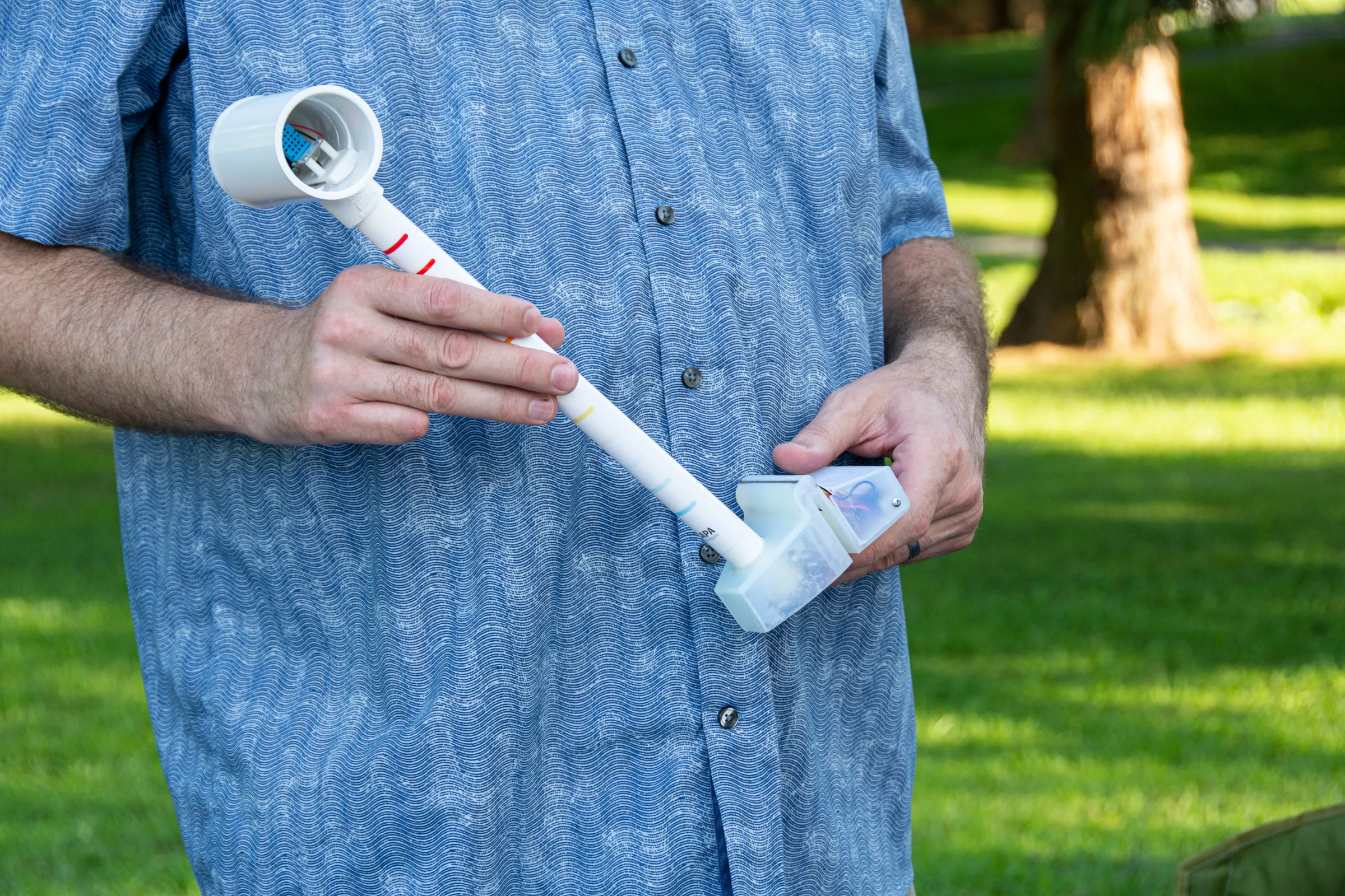 A participant holds a sensor for measuring temperature, humidity and more amid an urban heat island mapping effort in Montgomery County, Maryland