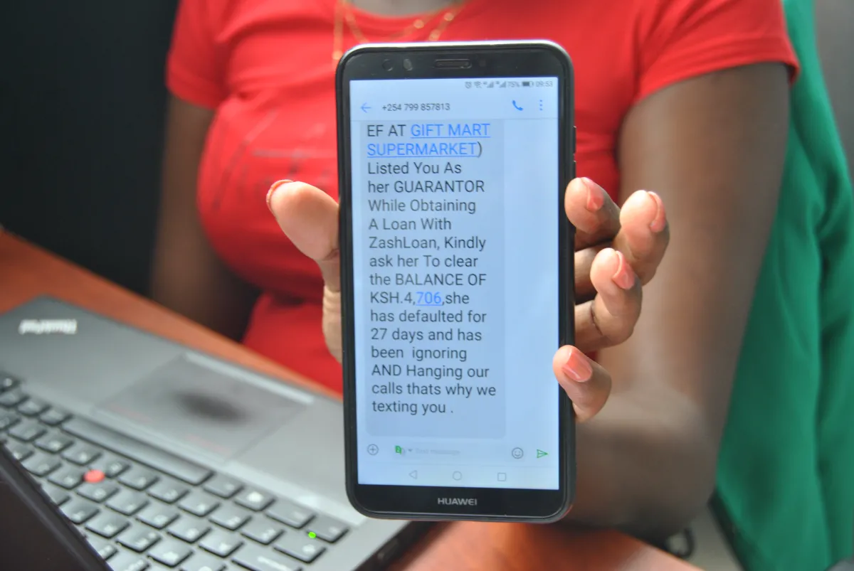 A Kenyan woman shows a text message sent by loan app ZashLoan in Nairobi, Kenya on November ‎19, ‎2021. Thomson Reuters Foundation/Dominic Kirui