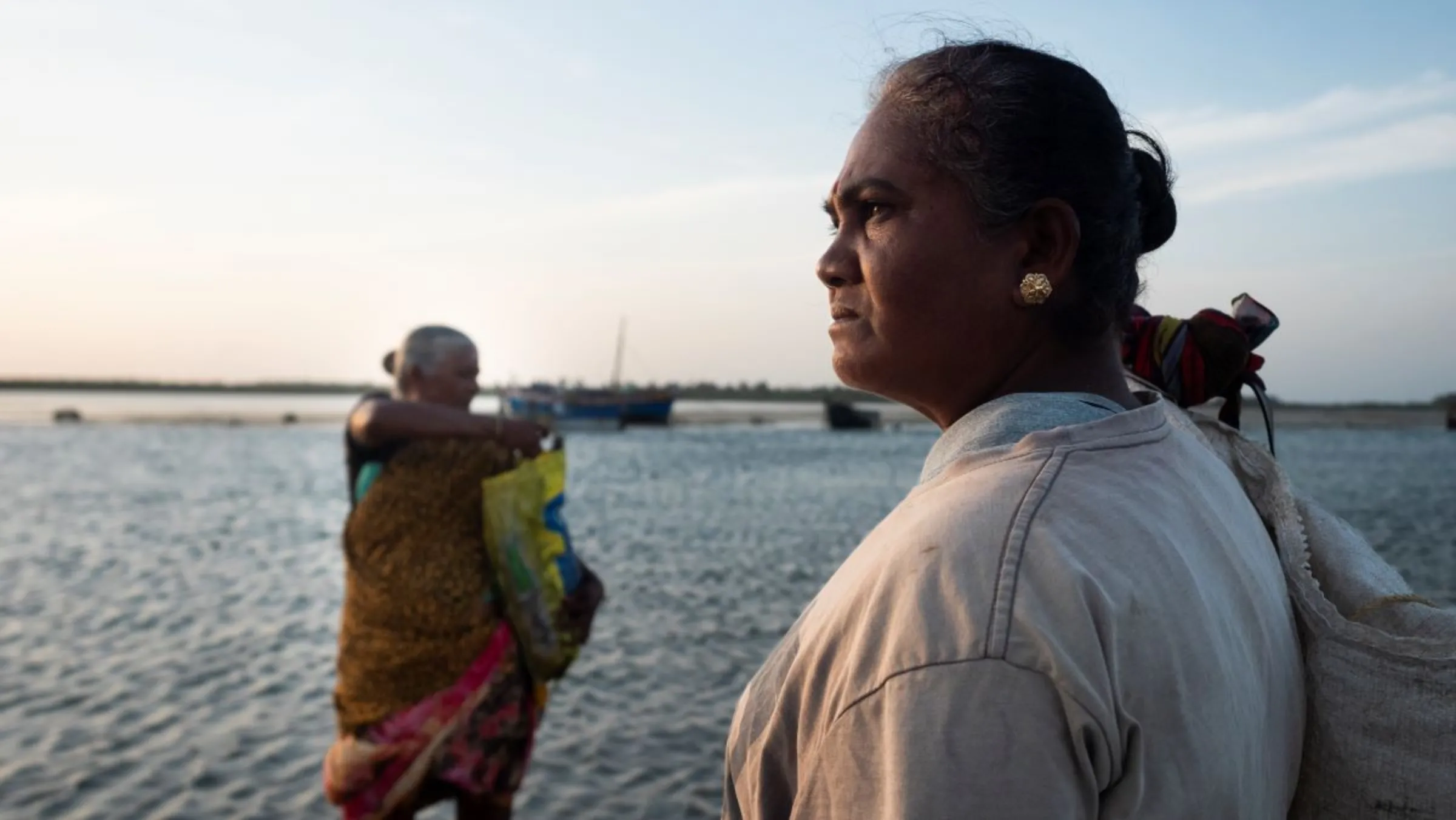 A female seaweed collector wades through a shallow bay to get to her boat in Rameswaram, India on July 17, 2023. Thomson Reuters Foundation/Nirbhay Kuppu