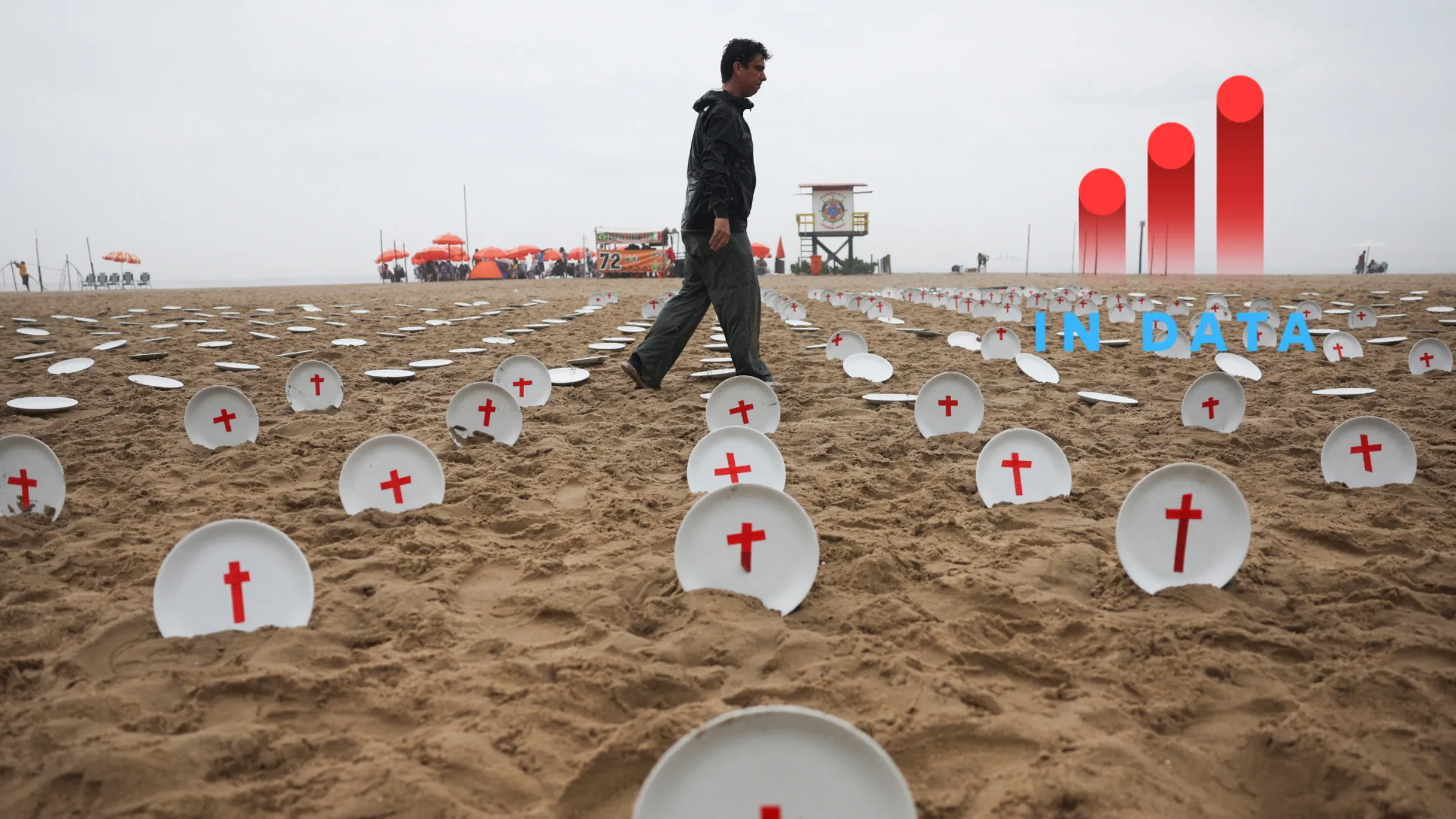A man walks near an installation of 733 empty plates with red crosses on the sand of Copacabana beach, representing the 733 million people who suffer from hunger worldwide, ahead of the G20 summit in Rio de Janeiro, Brazil November 16, 2024. REUTERS/Pilar Olivares