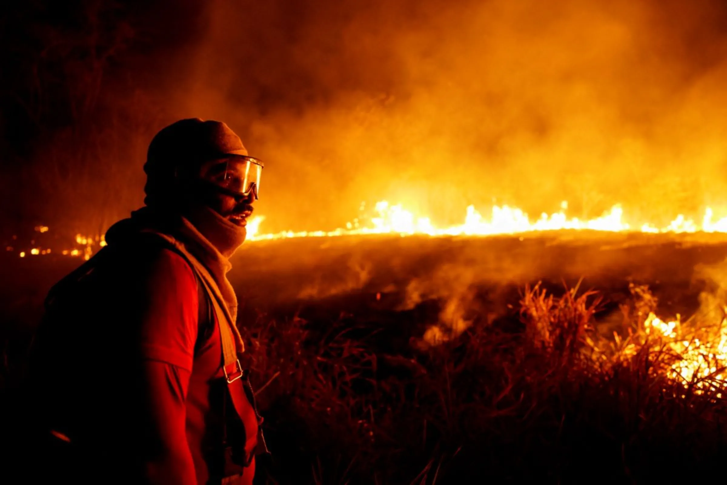 A firefighter looks on during the efforts to control fire in a rainforest located in the municipality of Canta, Roraima state, Brazil February 29, 2024. REUTERS/Bruno Kelly