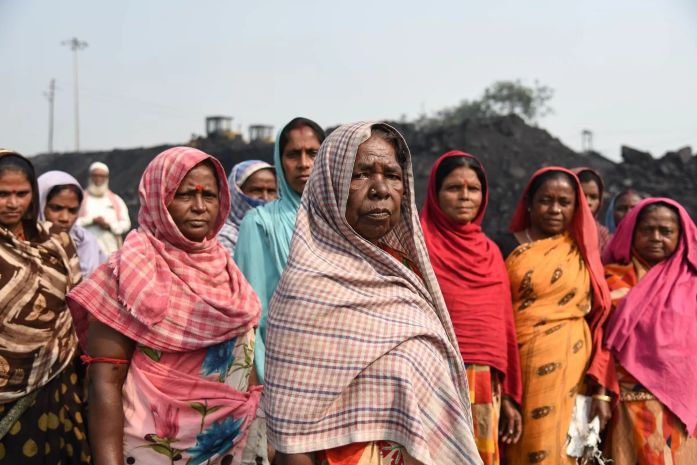Women coal loaders pose for a picture in Jharia coalfield, India, November 10, 2022. Thomson Reuters Foundation/Tanmoy Bhaduri