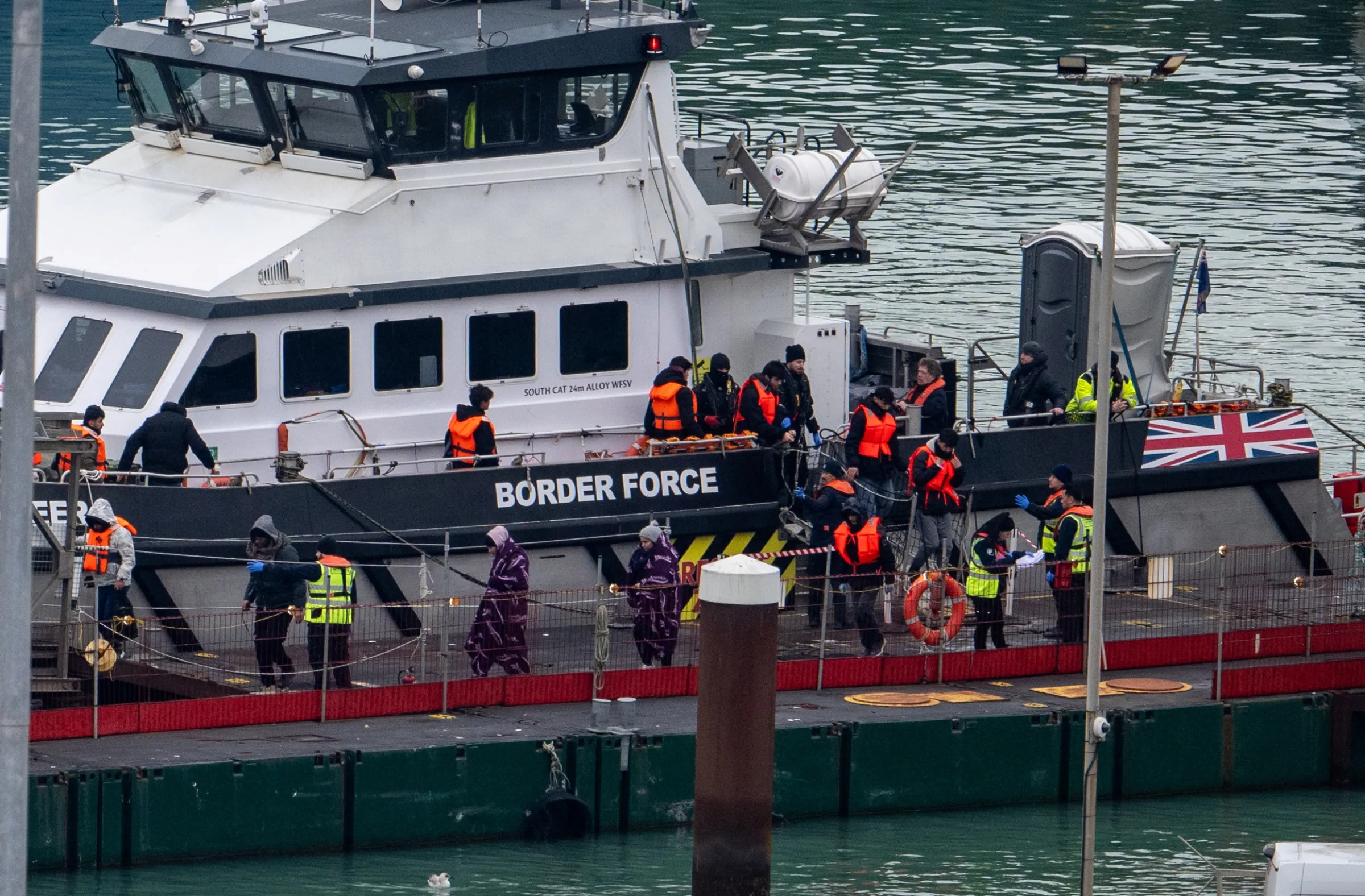 People, believed to be migrants, disembark from a British Border Force vessel as they arrive at the Port of Dover in Dover, Britain, January 15, 2025. REUTERS/Chris J. Ratcliffe