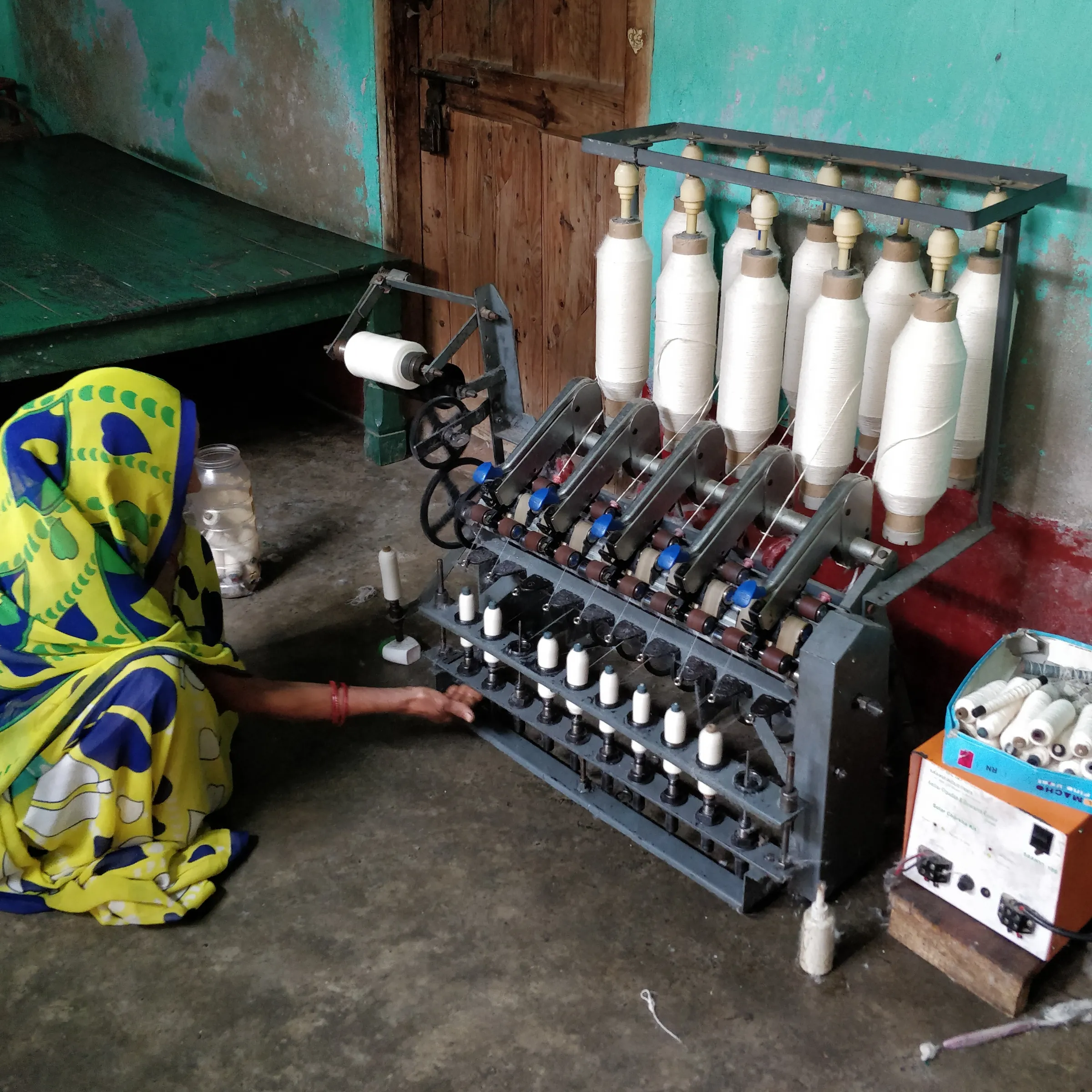 Anita Devi spins on her solar charkha in her home