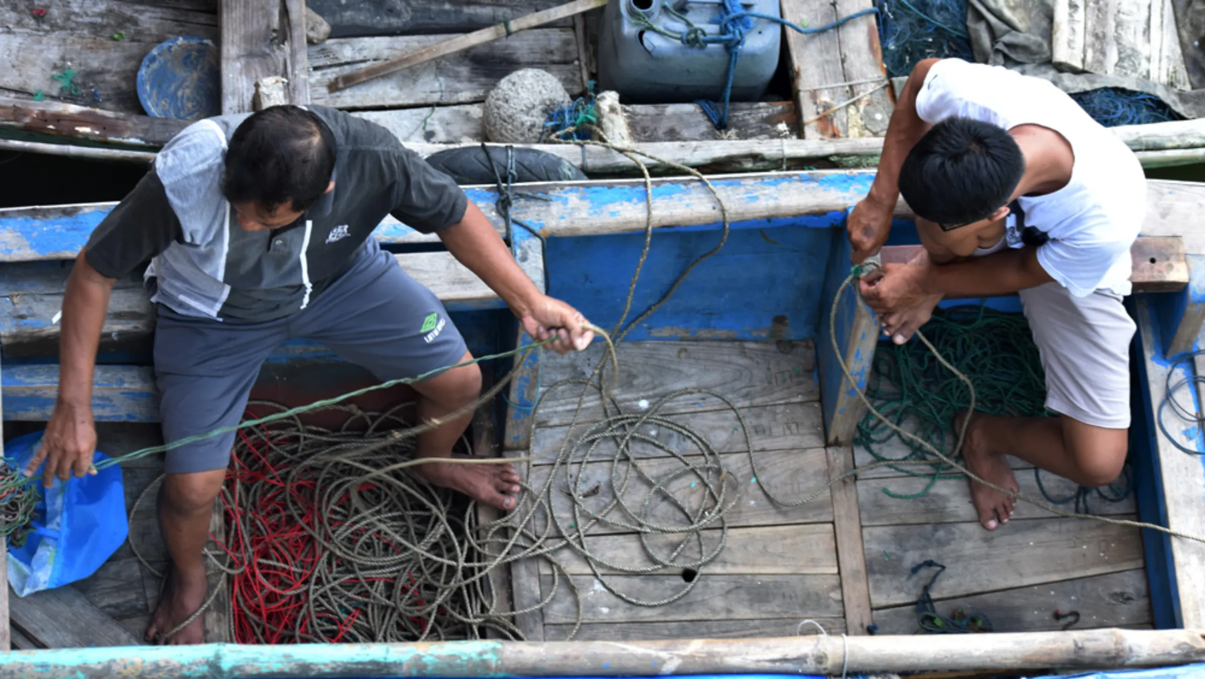 Fishermen check the condition of a boat on the Karanggeneng River, in Rembang regency, August 12, 2022