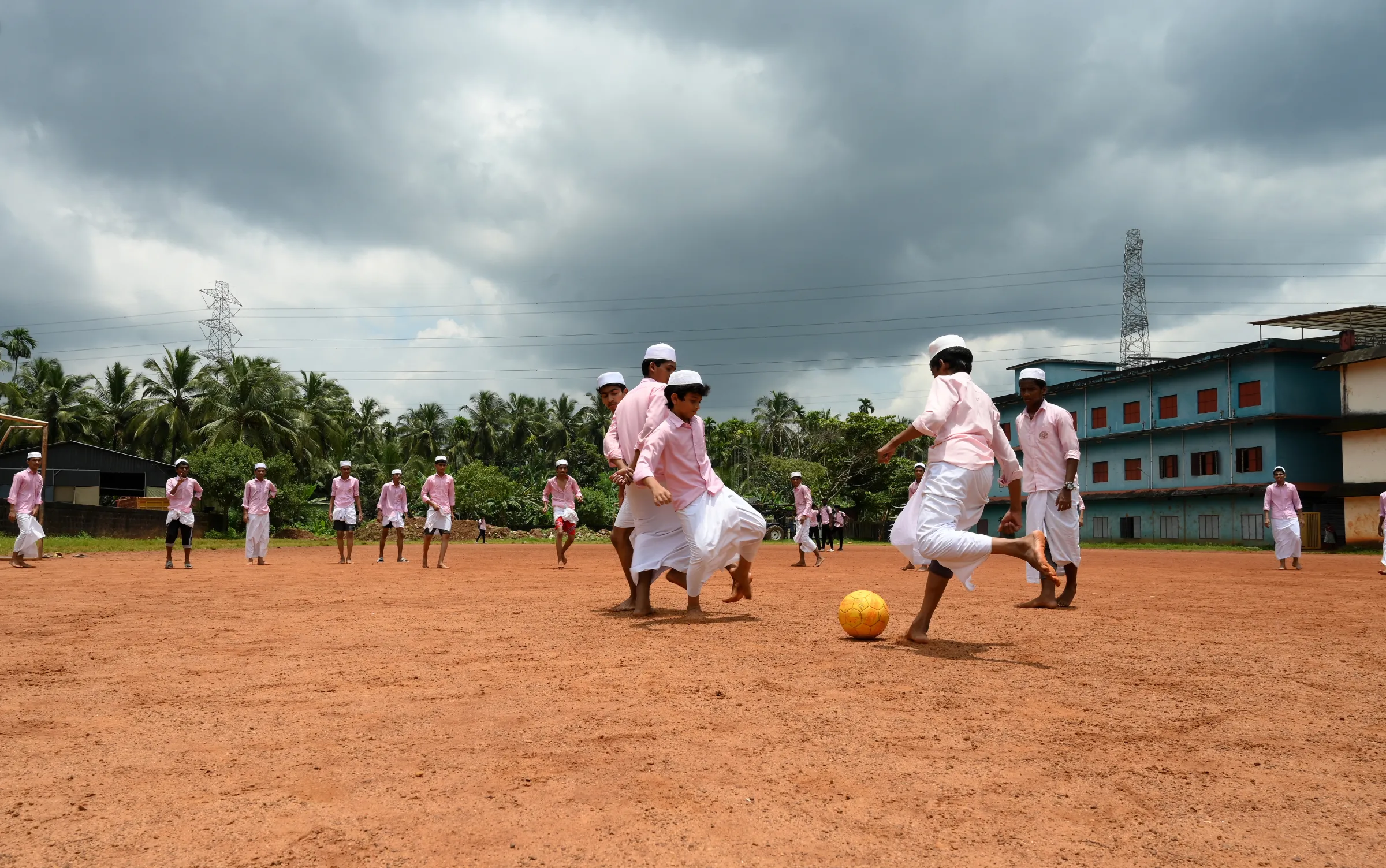 Students playing football at the Pookkottur government higher secondary school ground in Malappuram, India, August 29, 2022. Thomson Reuters Foundation/Gokul