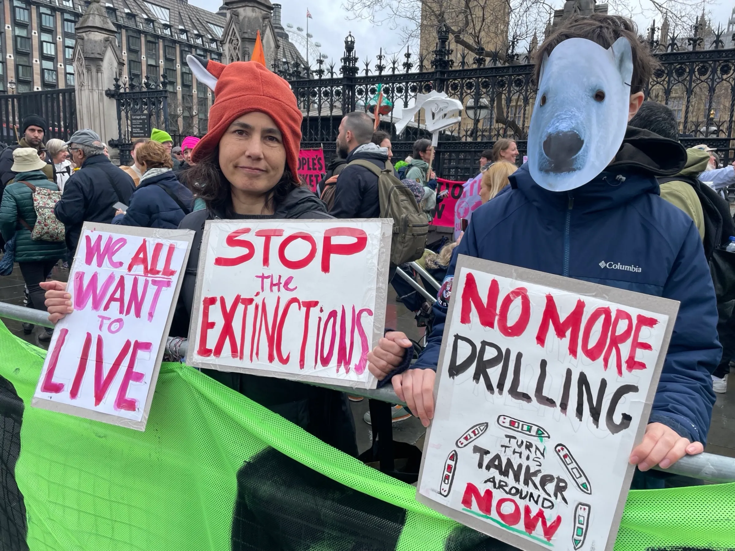 Activists, one in a polar bear mask, display signs at “The Big One”, a protest organised by Extinction Rebellion outside Parliament in London on April 21, 2023. Thomson Reuters Foundation/Laurie Goering