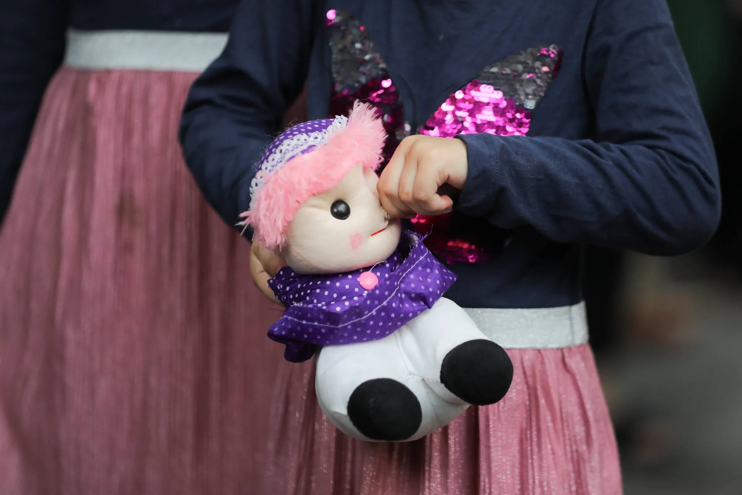 An Afghan girl holds a doll during a protest outside the United Nations High Commissioner for Refugees (UNHCR) office to urge the international community to help Afghan refugees, in New Delhi, India, August 23, 2021.