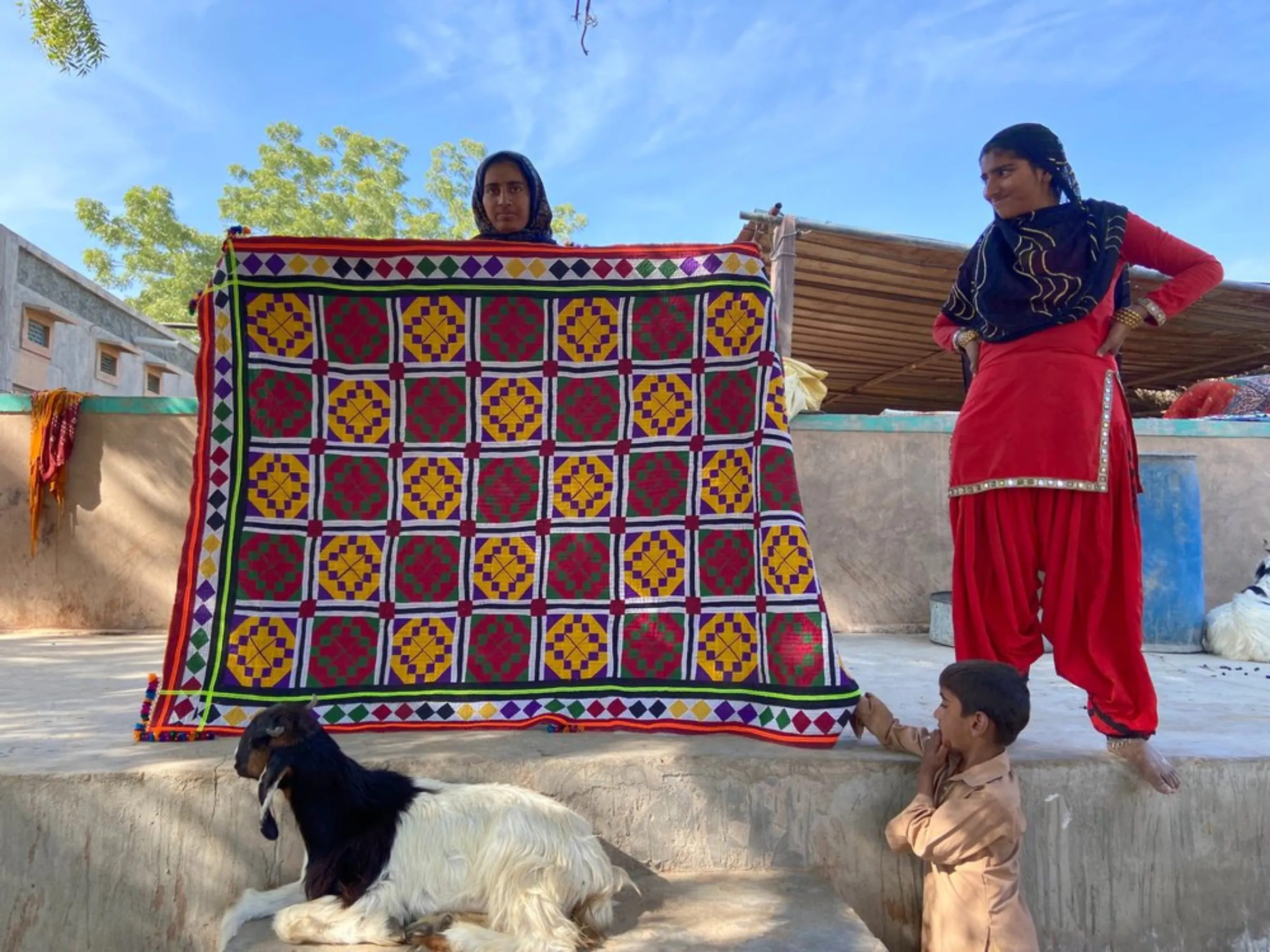 A young girl shows a rug she has stitched for her dowry in Bhadla, India, on December 11, 2021