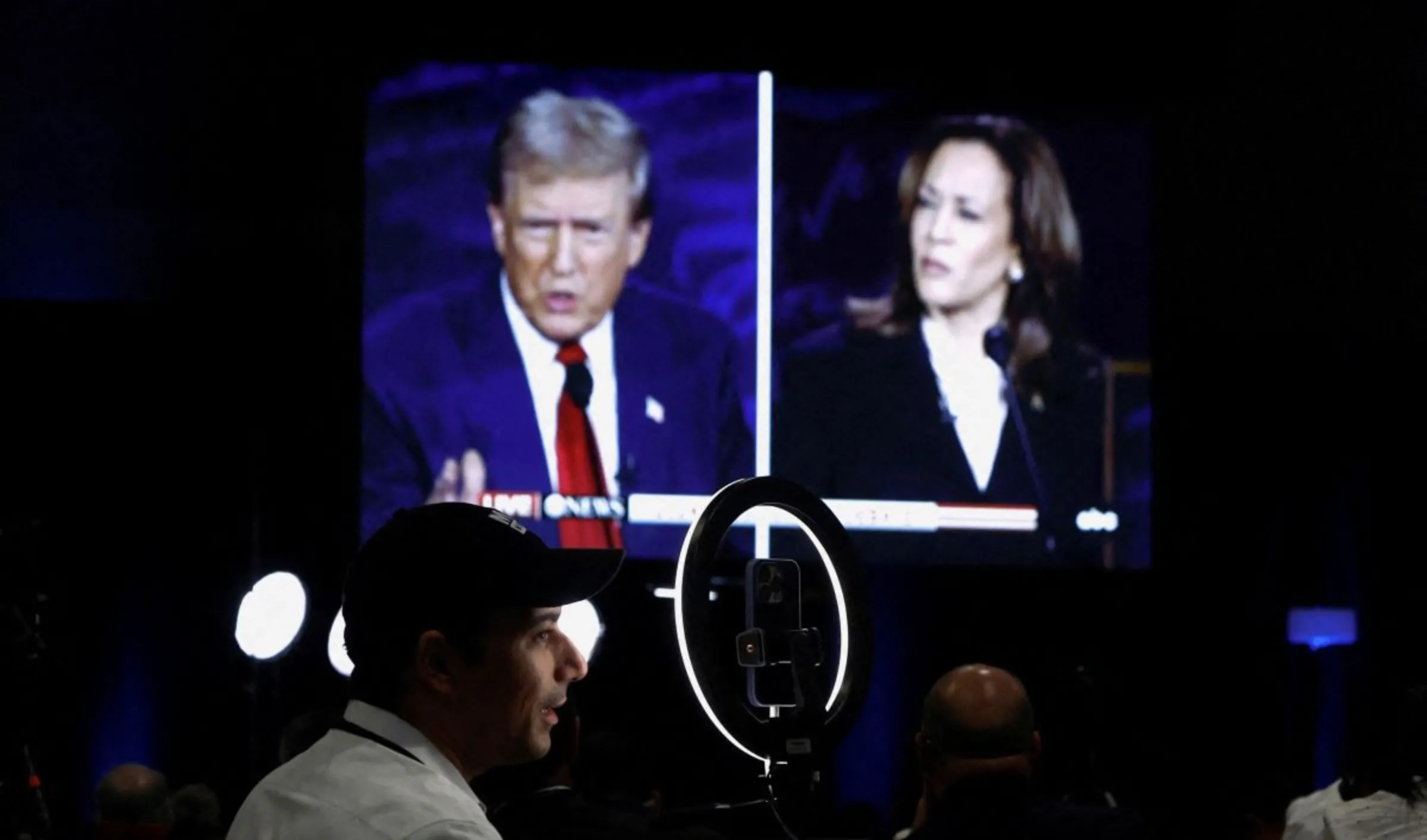 Members of the media use a screen to watch the presidential debate hosted by ABC in Philadelphia, Pennsylvania, U.S., September 10, 2024. REUTERS/Evelyn Hockstein