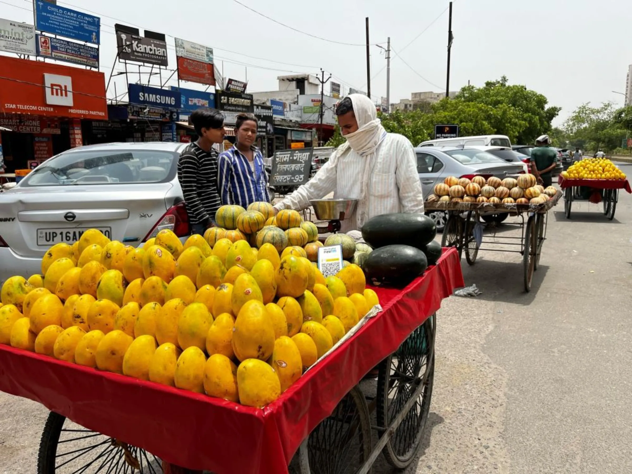 Fruit seller Mohammad Ikrar waits for customers during an intense heatwave in Noida, India, May 18, 2022