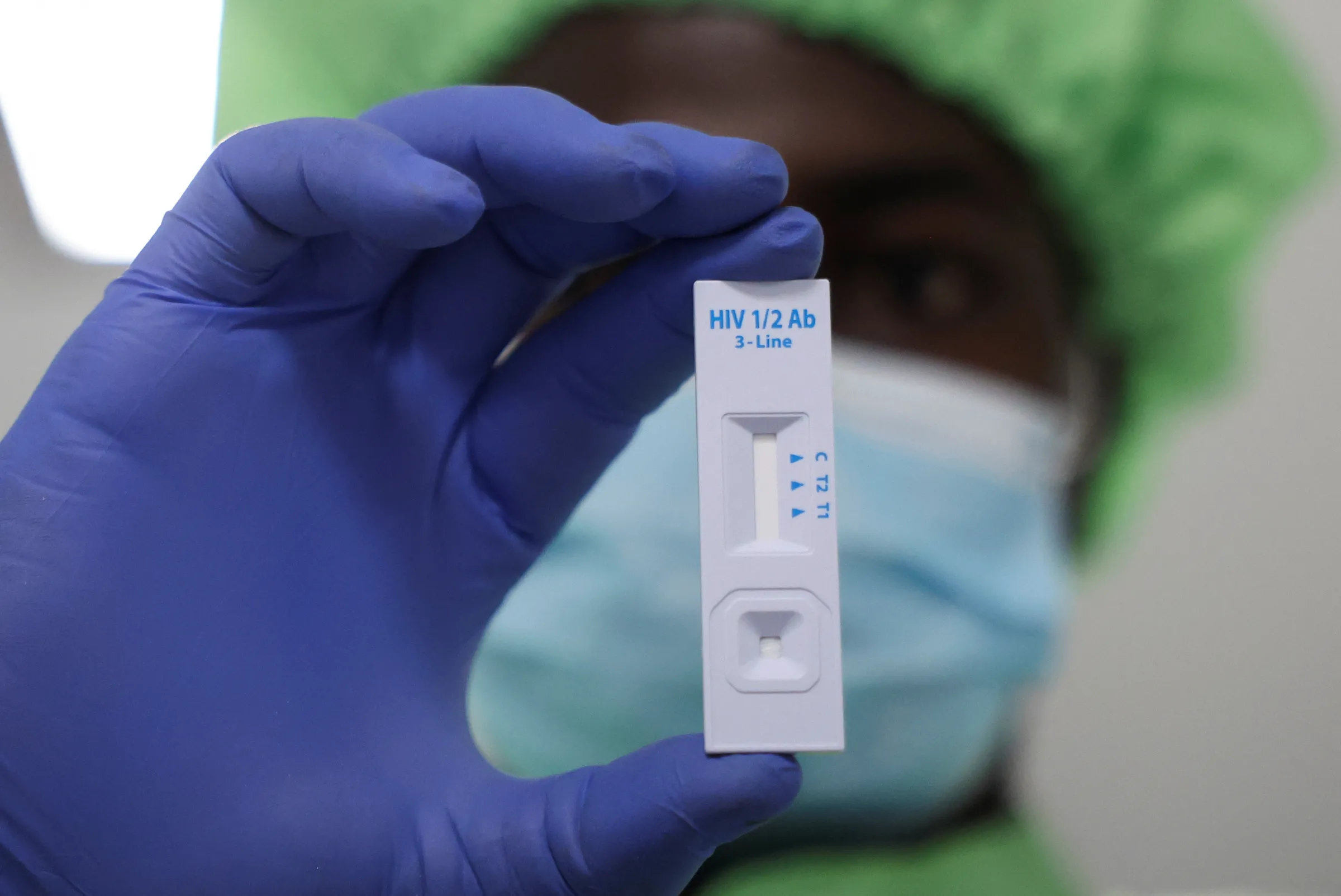 A worker displays a plastic test cassette for HIV 1/2 at Codix Bio production plant where HIV and Malaria test kits are locally produced, as it aims to fill the gap left by U.S. funding cuts to USAID, in Iperu-Remo in Ogun State, Nigeria, June 18, 2025. REUTERS/Sodiq Adelakun