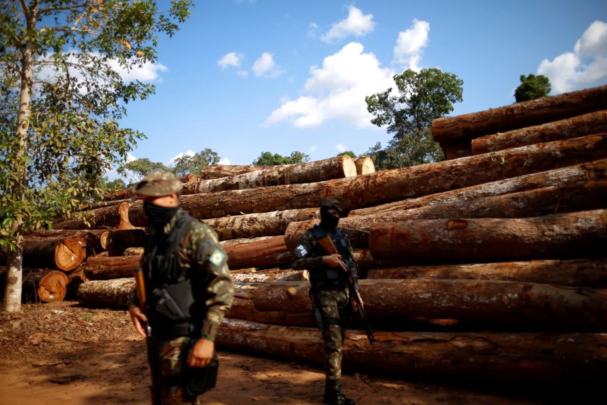 Brazilian Army soldiers are pictured near piles of legal wood in a wood company warehouse in the Amazon rainforest, inside Jamari National Forest Park in the County of Itapua do Oeste, Rondonia state, Brazil, September 28, 2021. REUTERS/Adriano Machado