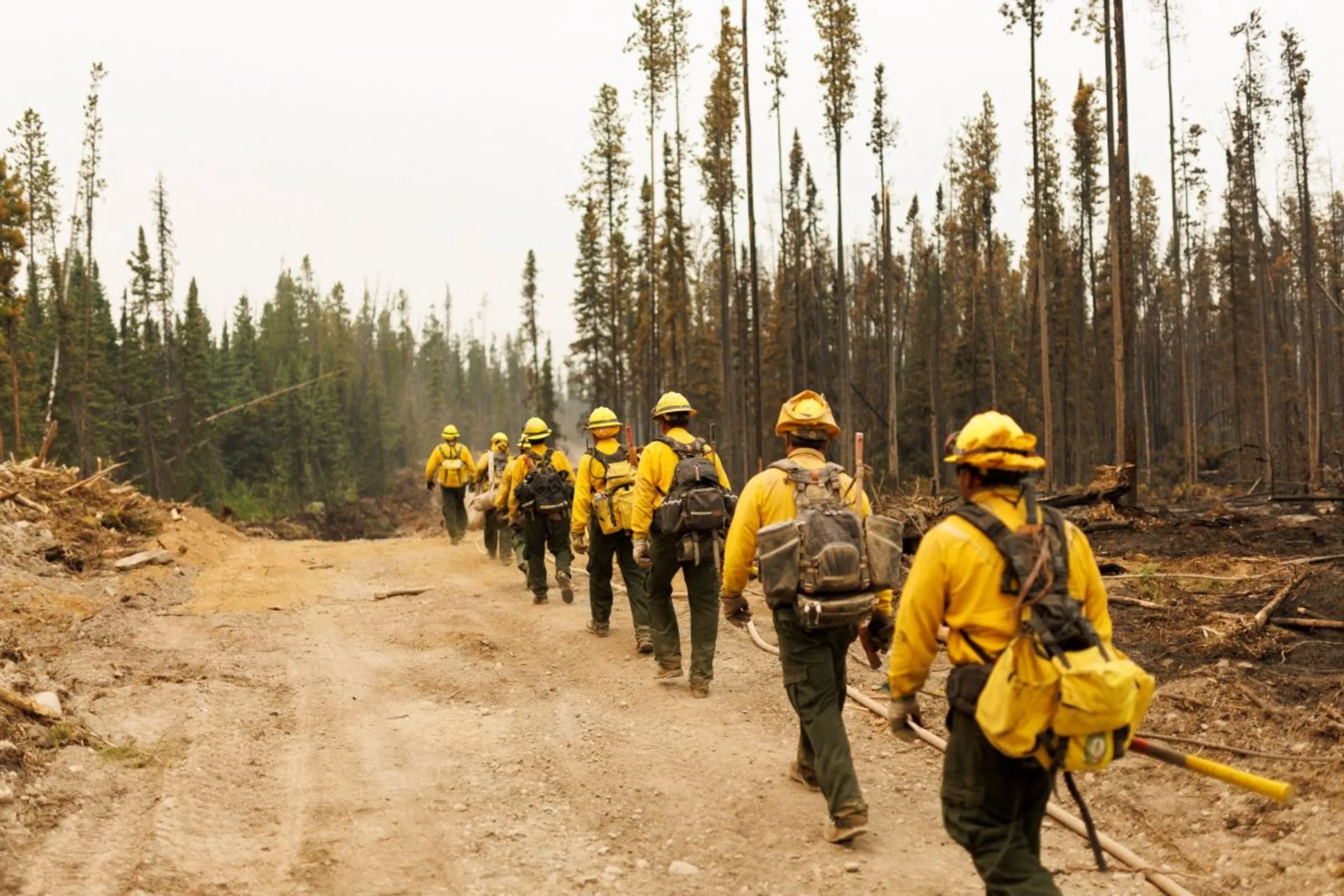 Firefighters from Mexico march along a fire guard as they battle wildfires near Vanderhoof, British Columbia, Canada July 13, 2023