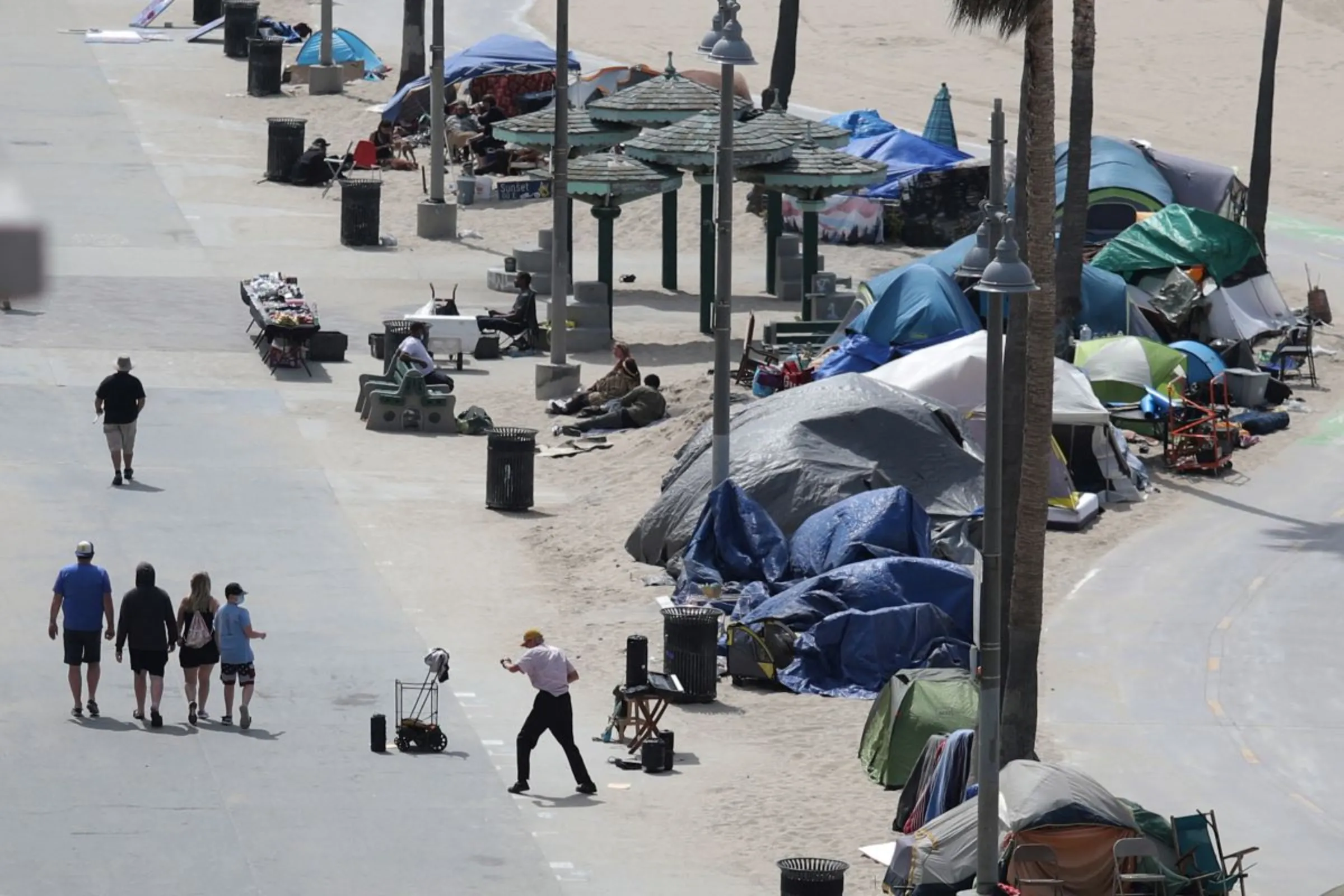 Homeless encampments line the bike path on Venice Beach in Los Angeles, California, U.S., April 14, 2021. REUTERS/Lucy Nicholson